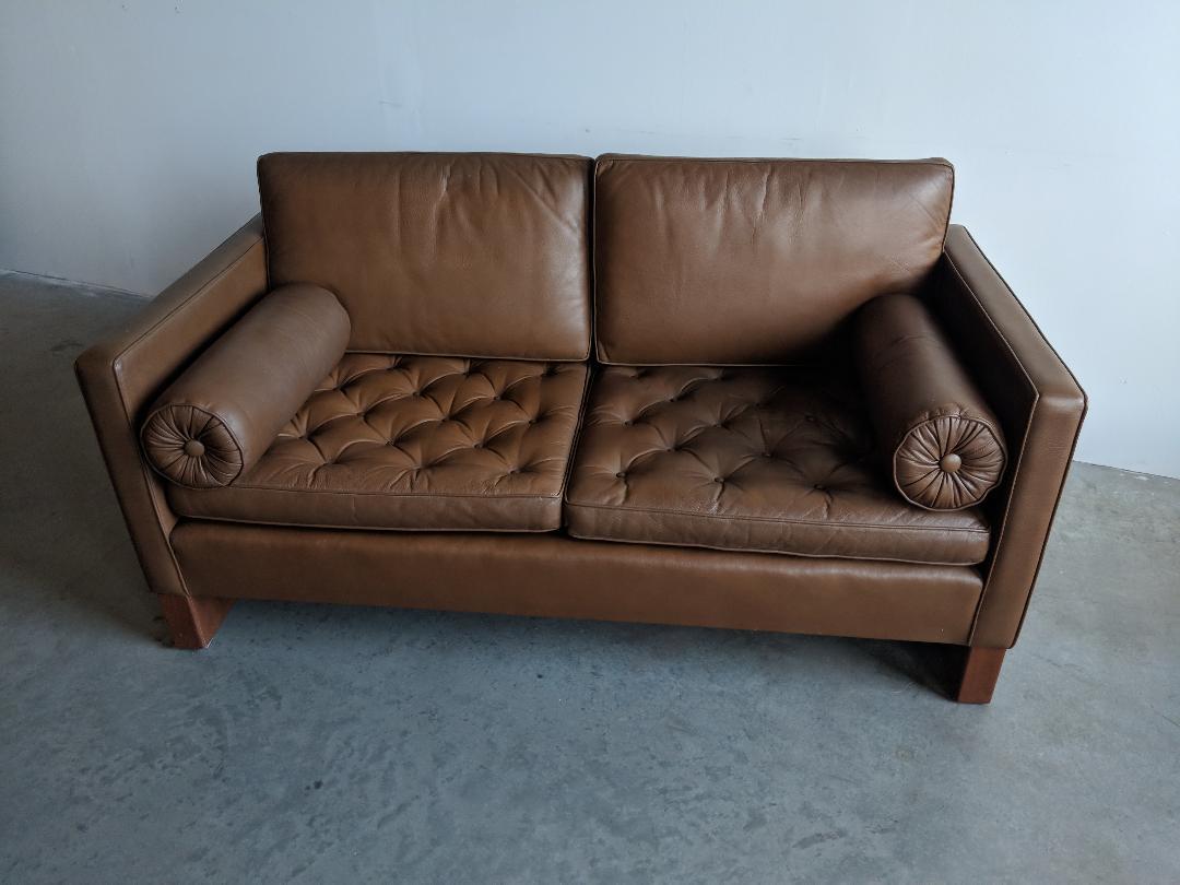 Settee designed by Mies van der Rohe for Knoll International, circa 1968. We bought this from an architect who trained with Louis Kahn, and purchased it new in 1974. We would describe the color as a medium brown. The sled bases are oiled walnut.