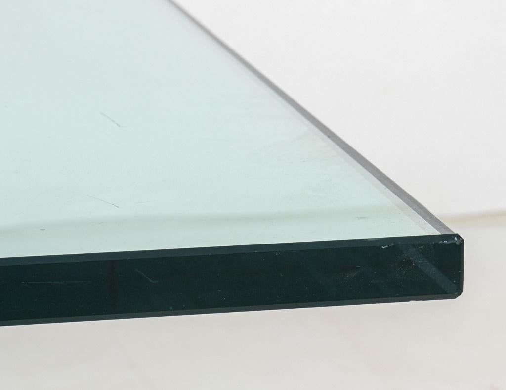 Moderner niedriger Tisch aus Messing und Glas, dessen geometrischer Sockel eine quadratische Platte trägt.  16