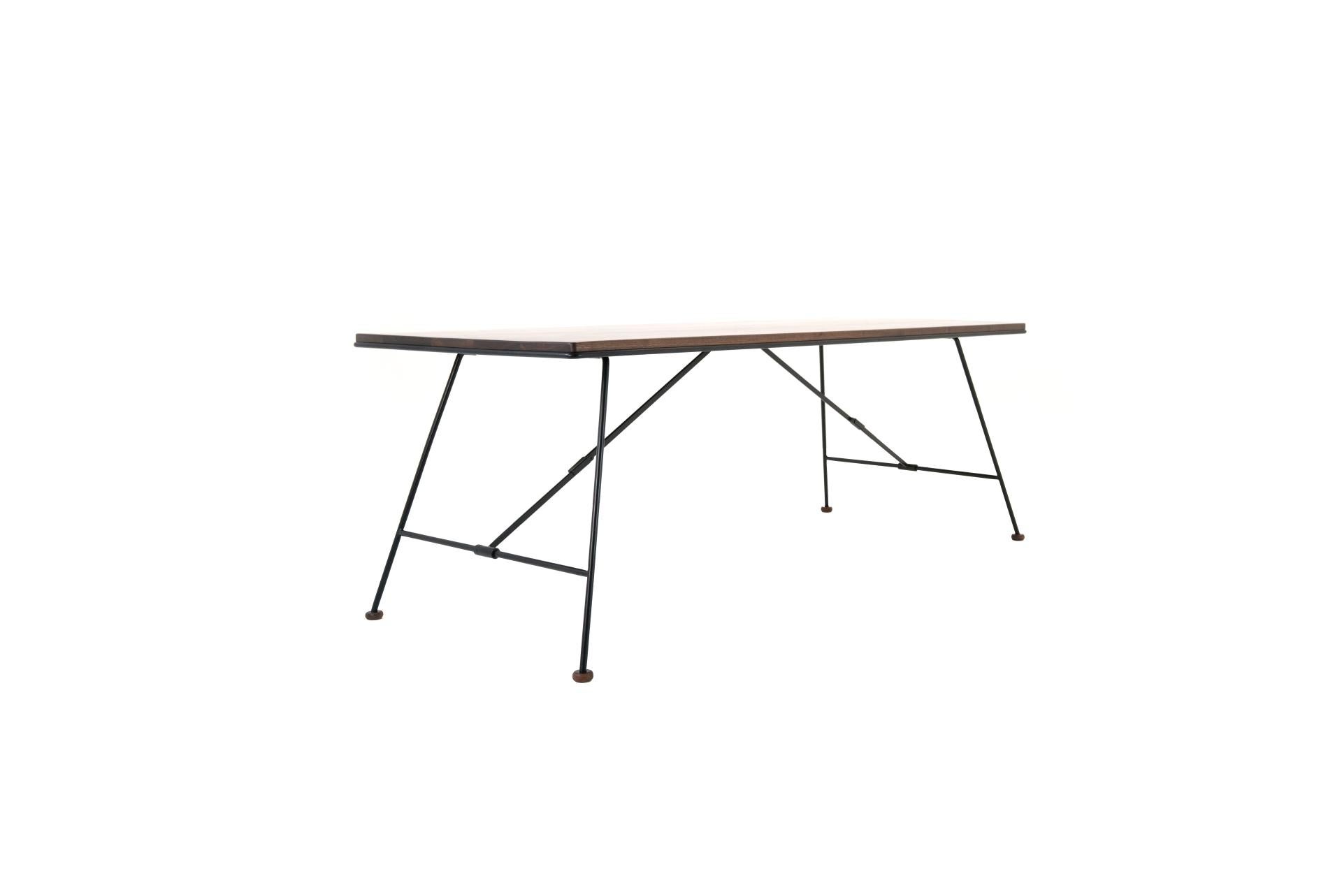 Inspirée des tables d'opération de campagne de l'ancienne école, la table pliante Mikado présente un plateau en bois massif et des pieds en acier massif. Dans un boîtier avec un bord en acier caractéristique pour protéger le bois lorsqu'il est plié