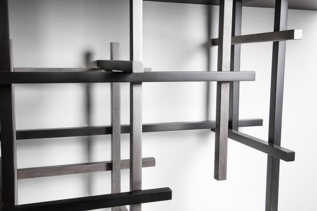 The floating version of Mikado Line in its combination of materials and a crisscross, dynamic base.
It's made of Silver leaf patinated wood top, gun metal and two types of patinated silver leaf metal base.