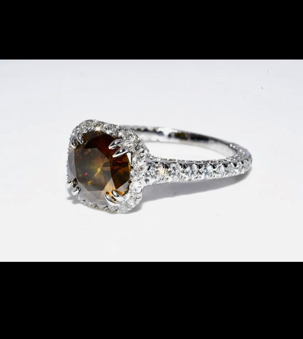GIA Certified Fancy Color Diamond: 1.92cts   
 
Color: Fancy Dark Orange-Brown  Even       
 
Natural Side Brilliant Round Cut White Diamonds: 1.00cts   
 
Type of Metal: 14K Solid White Gold Ring
Gram Weight: 3.8 Grams
Ring Size: 6.25
Can This Ring