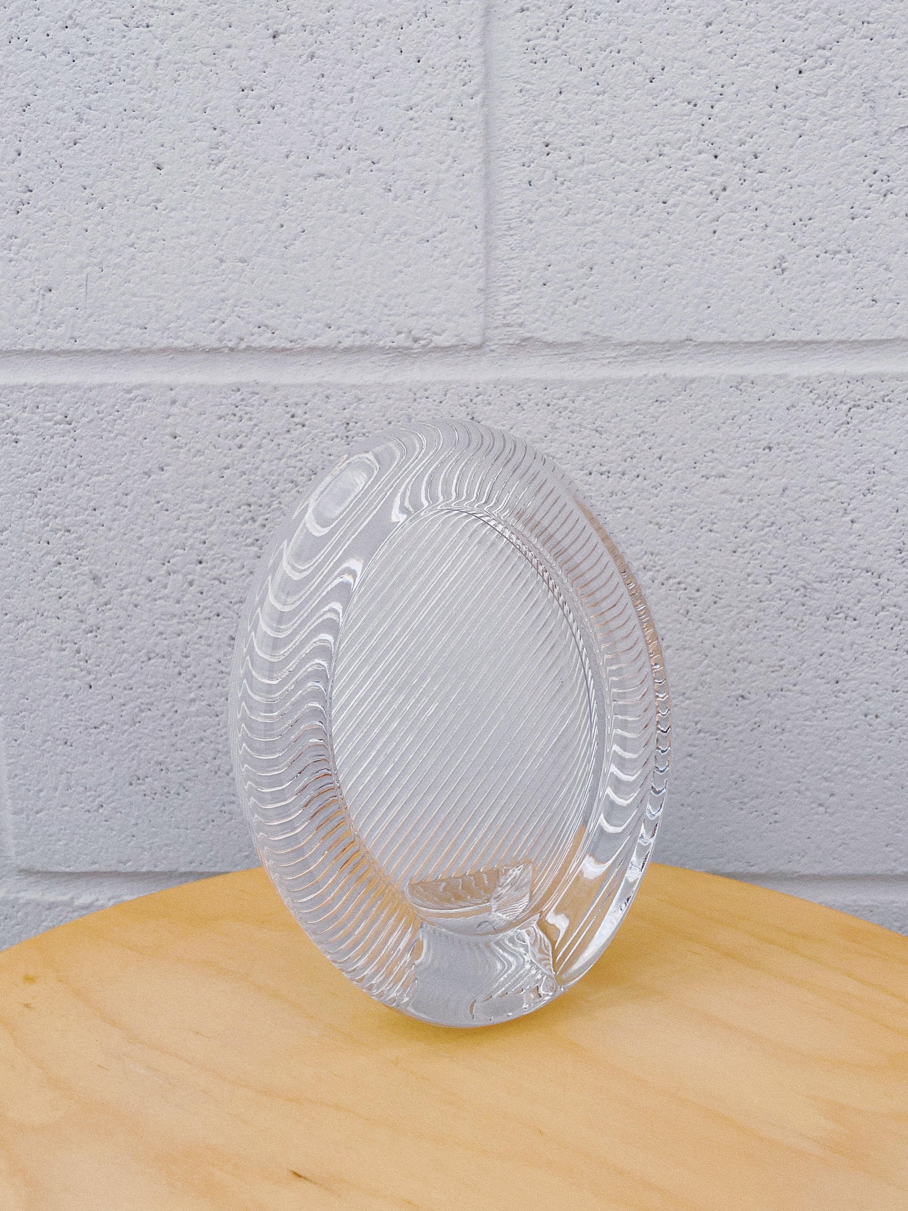 Add a touch of elegance to your home décor with this Mikasa Japan heavy solid glass oval picture frame. Crafted from .75” thick crystal glass, it showcases a stunning ribbed wave pattern that adds texture and sophistication. This free-standing frame