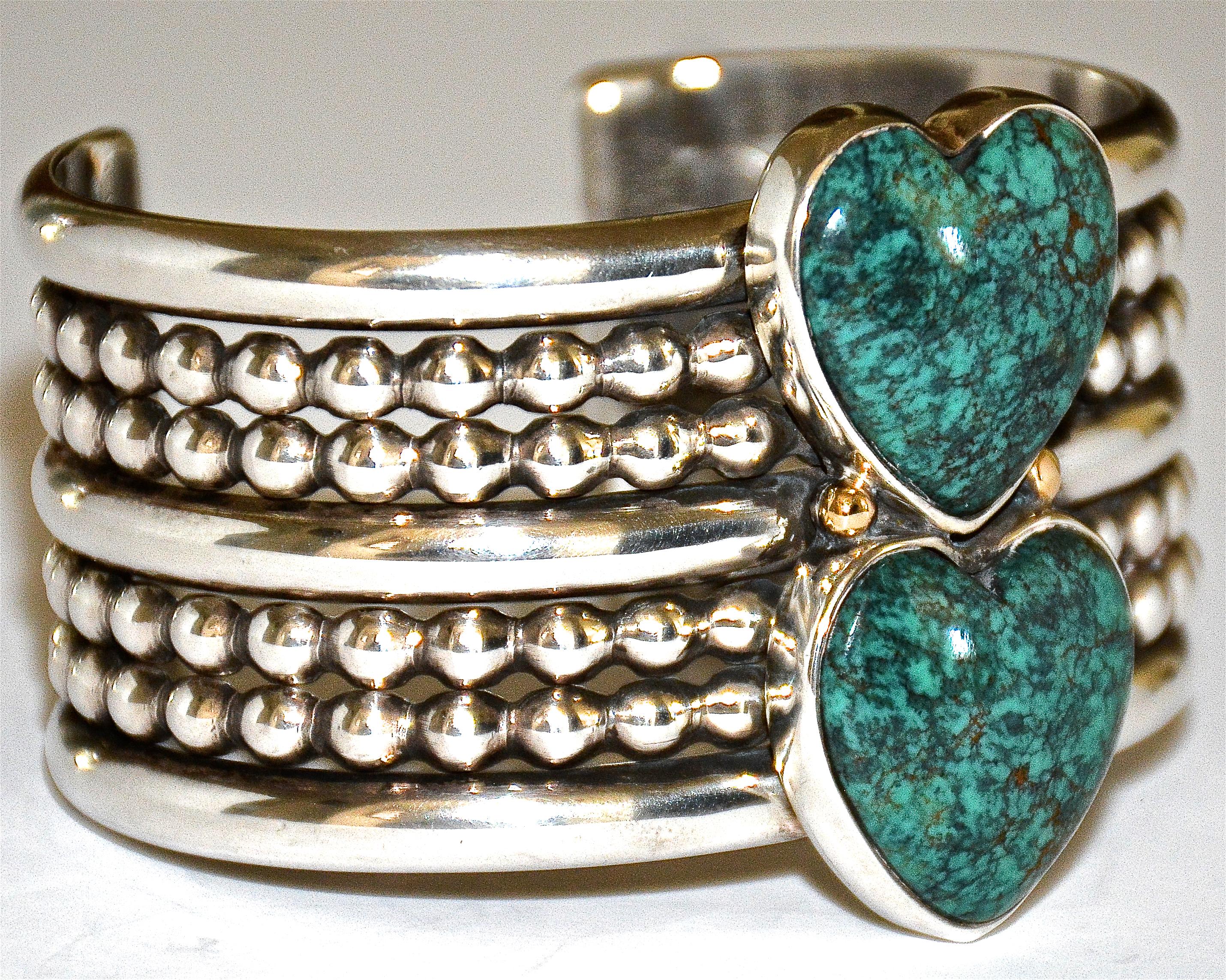 Elegant and beautiful Sterling Silver 7 Row Cuff Bracelet with Stormy Mountain Natural Turquoise Hearts by Mike Bird-Romero made in 1993. The two large stacked turquoise hearts are separated by two small gold capped balls. Stamped with Mike Bird's