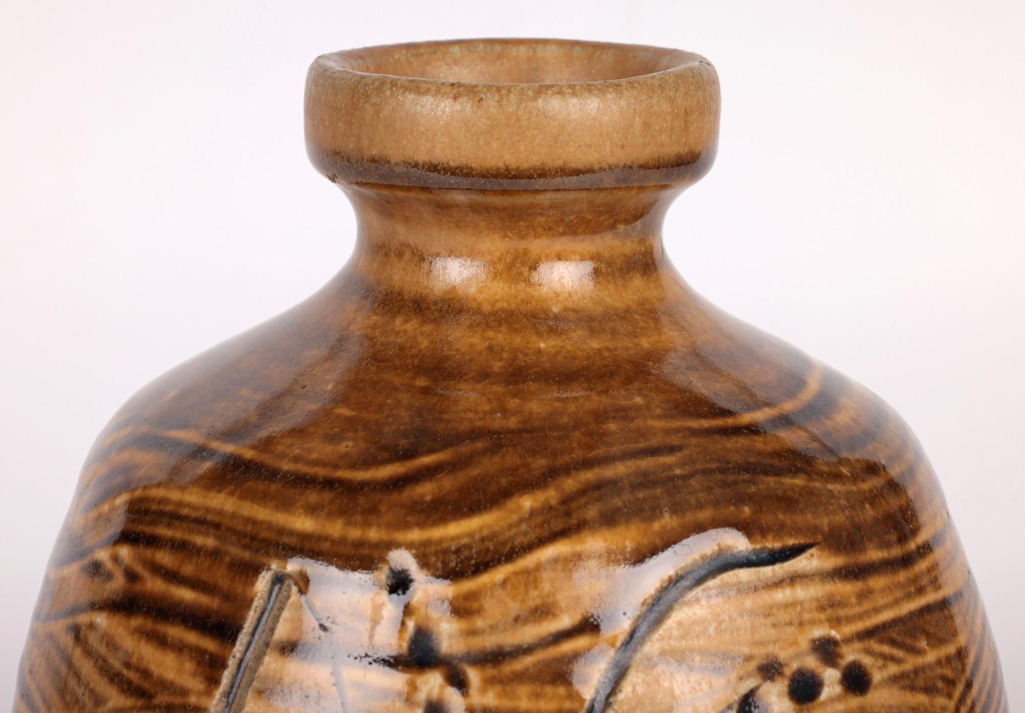 Un élégant vase en poterie de studio en grès émaillé cendré, décoré de graminées, réalisé par le célèbre potier Mike Dodd (Britannique, né en 1943) et datant de la fin du 20e siècle. Le vase fortement empoté repose sur un étroit pied rond non