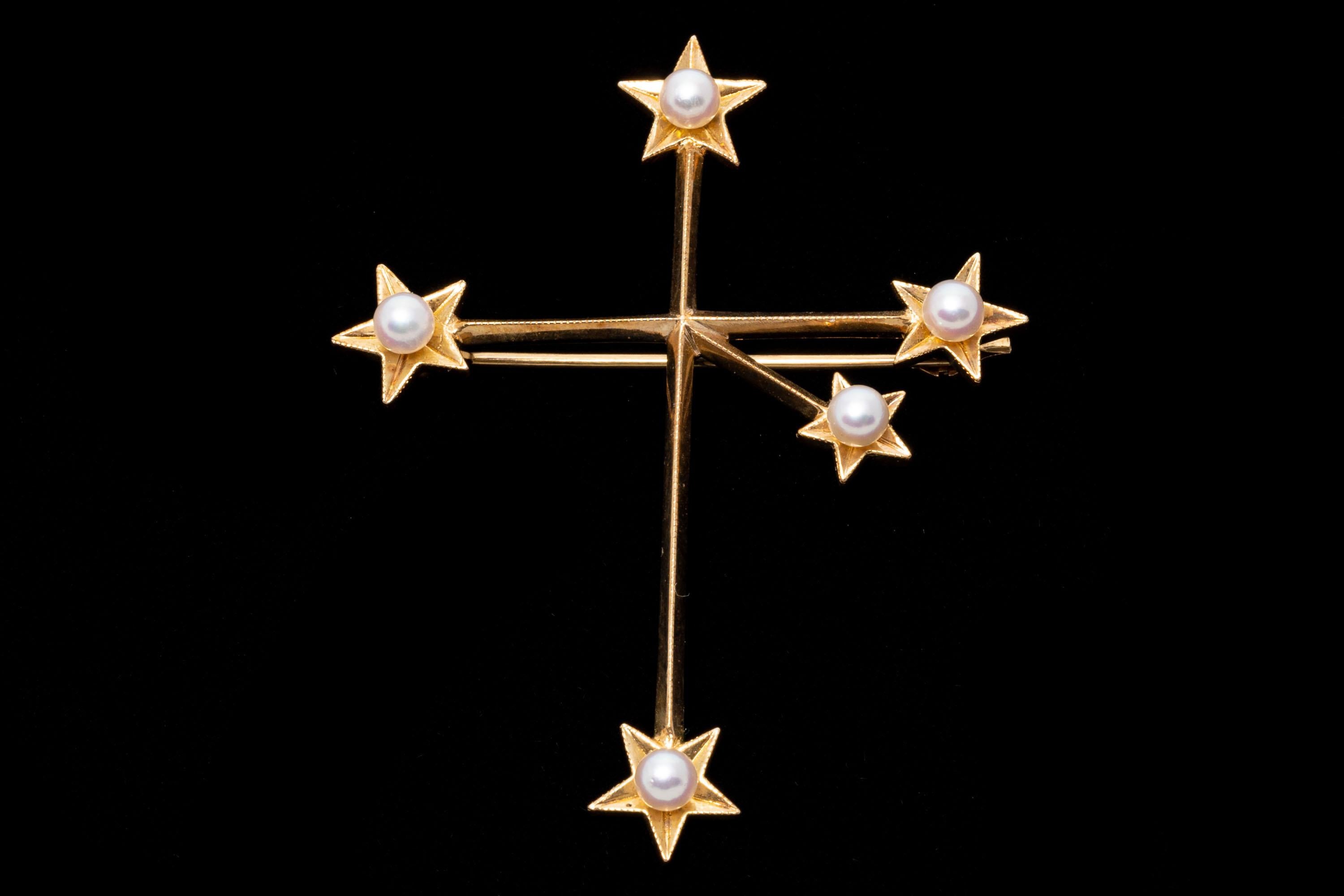 14k yellow gold brooch. This spectacular vintage brooch by Mikimoto is the Southern Cross constellation (the arms are intentionally slightly askew to mimic the stars in the sky). Each arm decorated with a five pointed shaped star end, set with a