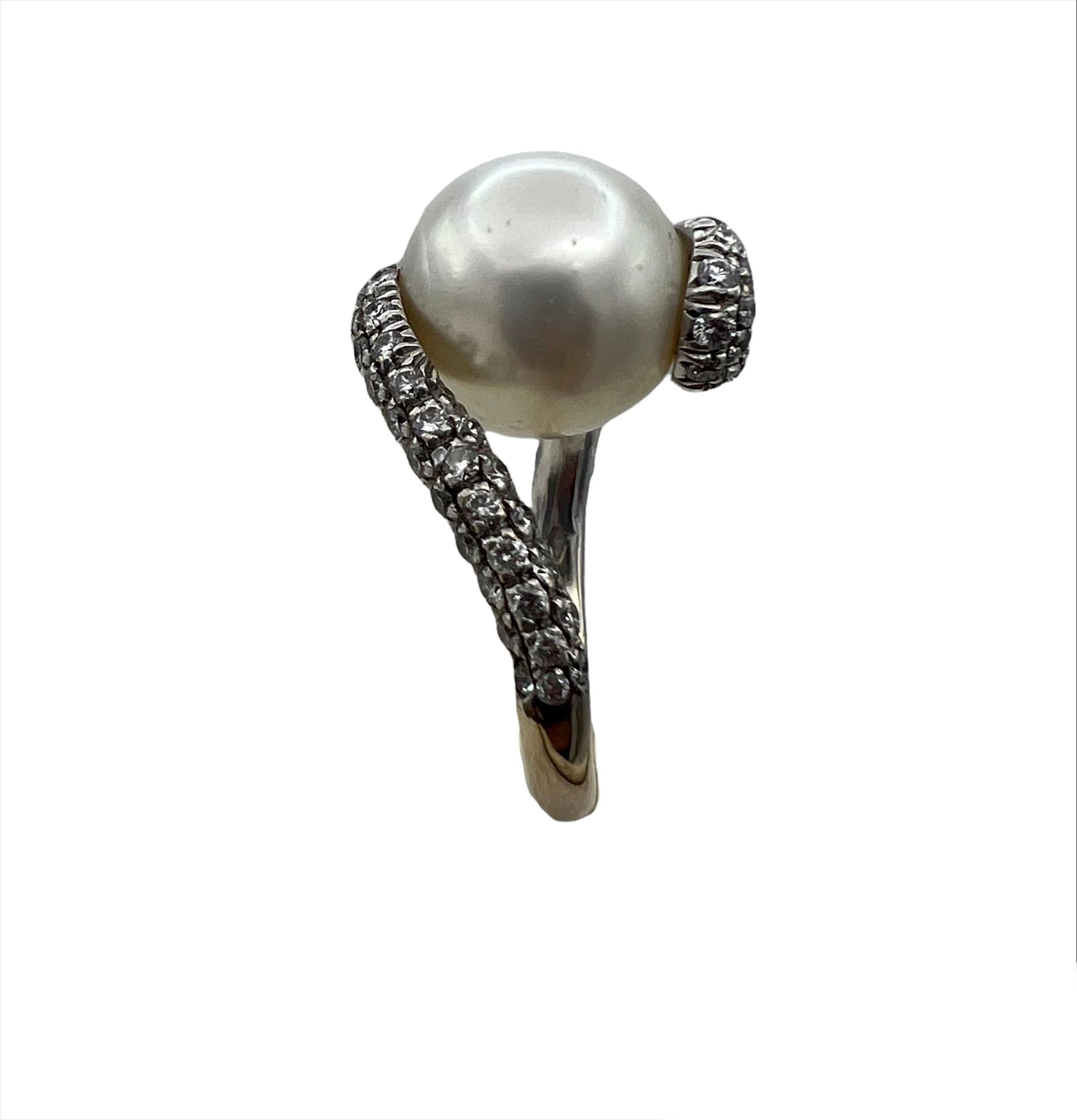 The ring features white cultured pearl, approx. 11.5mm, accented with 0.68 carats of round brilliant cut diamonds around it and set in 18k white gold.
Band width is 2.4 mm.
Ring size is 7.25.
Total weight is 8.1 grams.
Hallmarks: 750 and M for