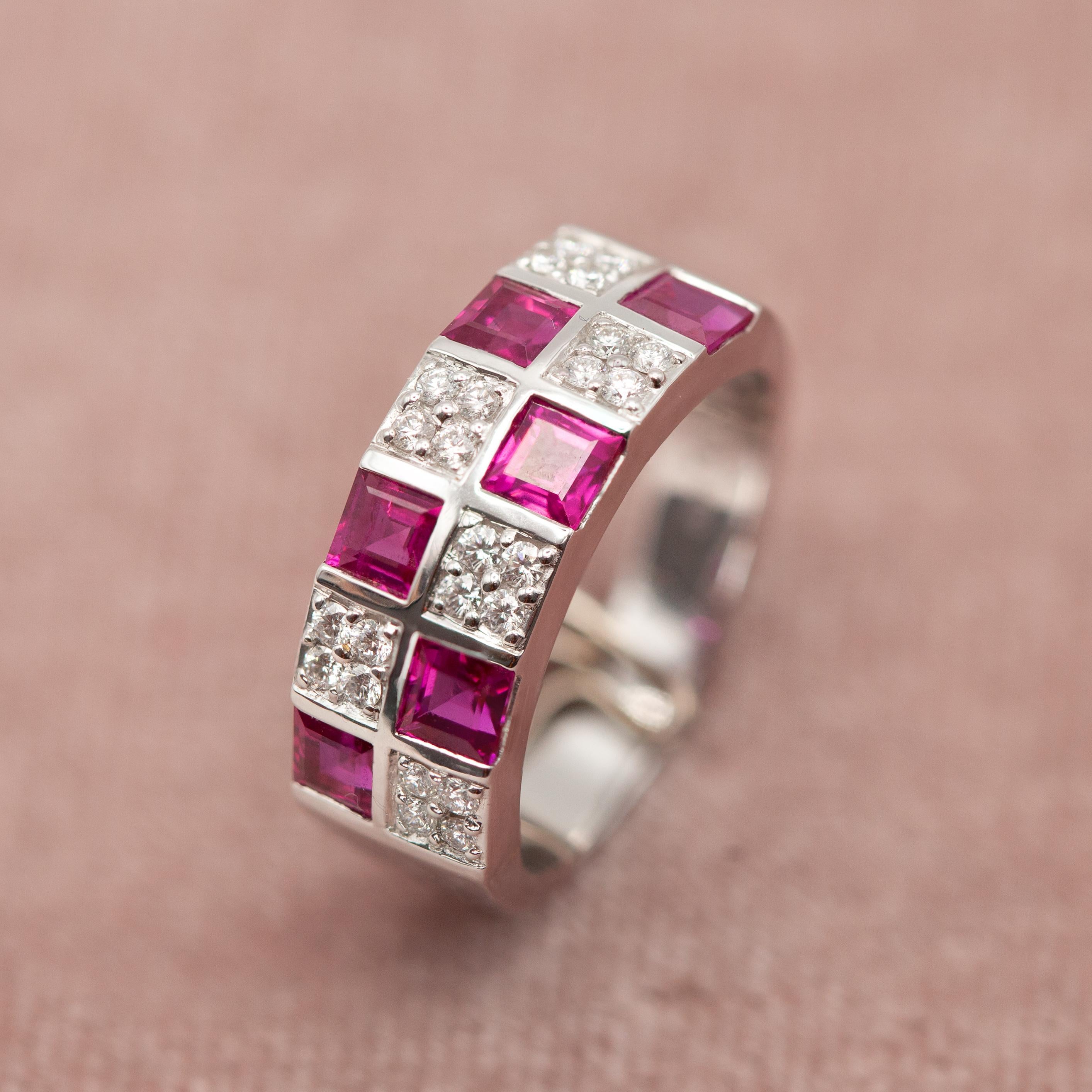 This striking band ring by Mikimoto crafted in 18K white gold features a modern geometric design set with six square cut rubies of rich, vivid red hue totaling approximately 1.40 carats. Alternating between the rubies are 24 brilliant-cut diamonds,