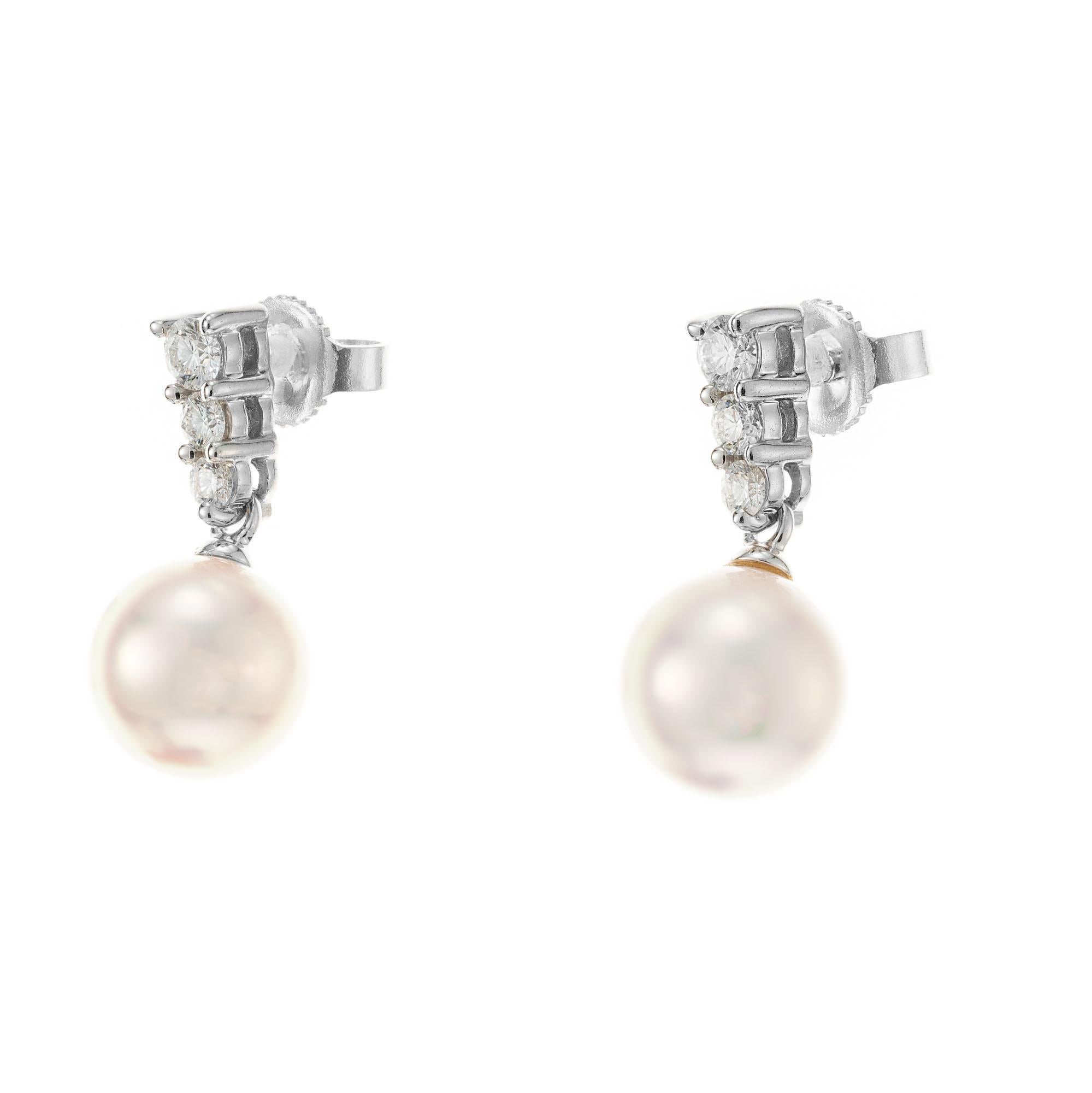 Mikimoto 8.5mm pearl dangle earrings in 18k white gold with 6 graduated brilliant cut accent diamonds. 

2 cultured rose hue pearls, 8.3mm-8.5mm
6 round diamonds, G VS approx. .30cts
18k white gold 
Stamped: 750
Hallmark: Mikimoto
3.5 grams
Top to