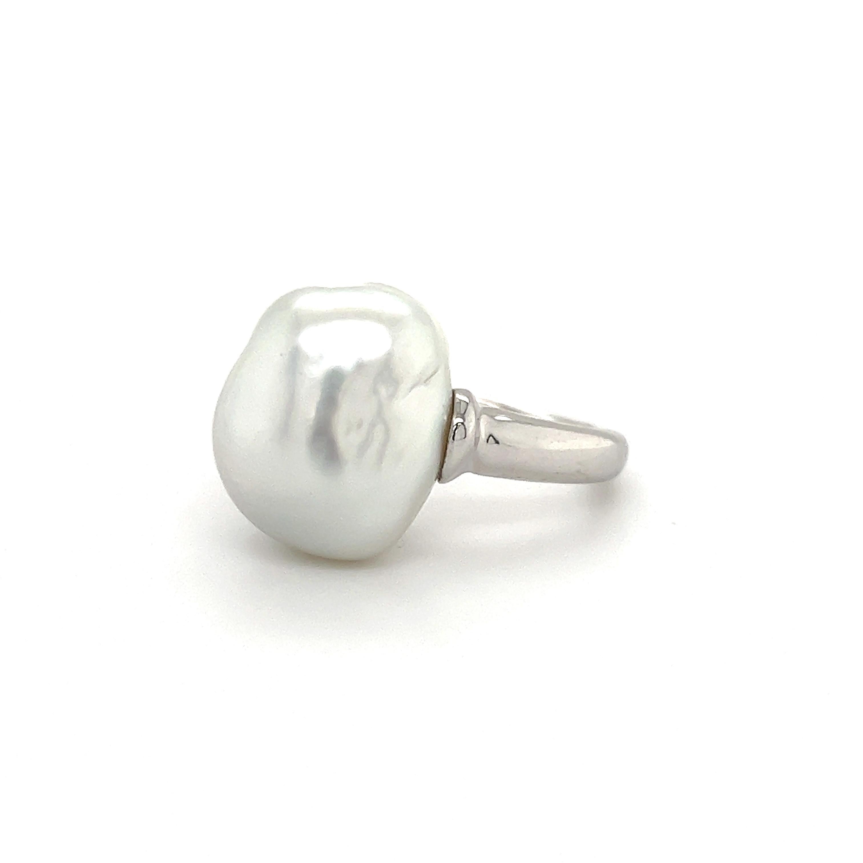 Beautiful design seen on this elegant Mikimoto ring. The highlight of the ring is one white baroque pearl gemstone that is tension set. The pearl appears to be floating in air, although simple, this ring is sure to grab attention whenever worn.  The