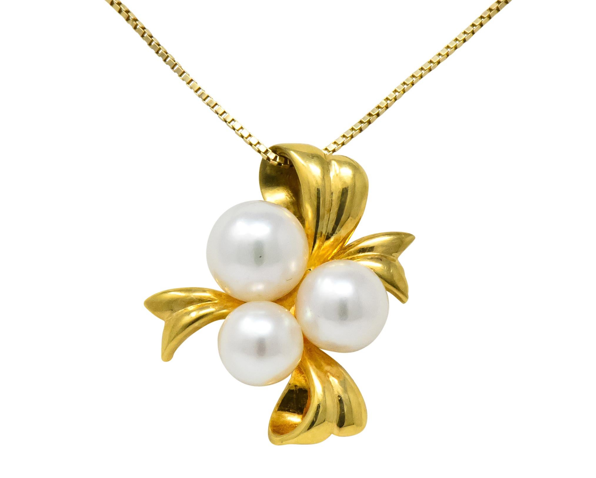 Centering an 18 karat gold pendant designed as ribbon with three round natural freshwater cultured pearls, white in color with rosé overtone and very good luster

Accompanied by 14 karat gold box chain, completed by lobster clasp stamped 14kt, Made