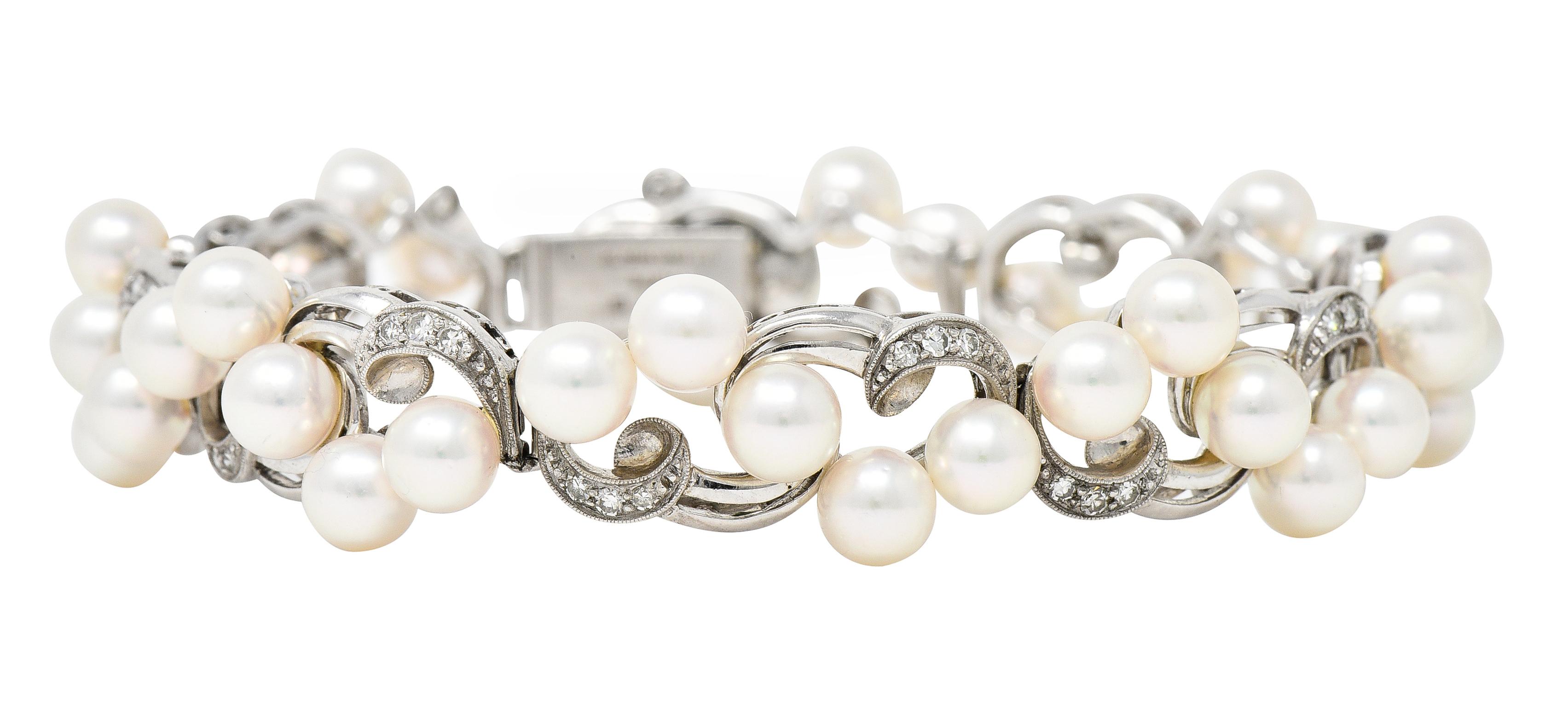 Comprised of hinged scroll motif links each featuring 5.0 mm round cultured pearls. White in body color with strong iridescence and excellent luster. Accented by single cut diamonds bead set in scrolls. Weighing approximately 0.64 carat total. G/H