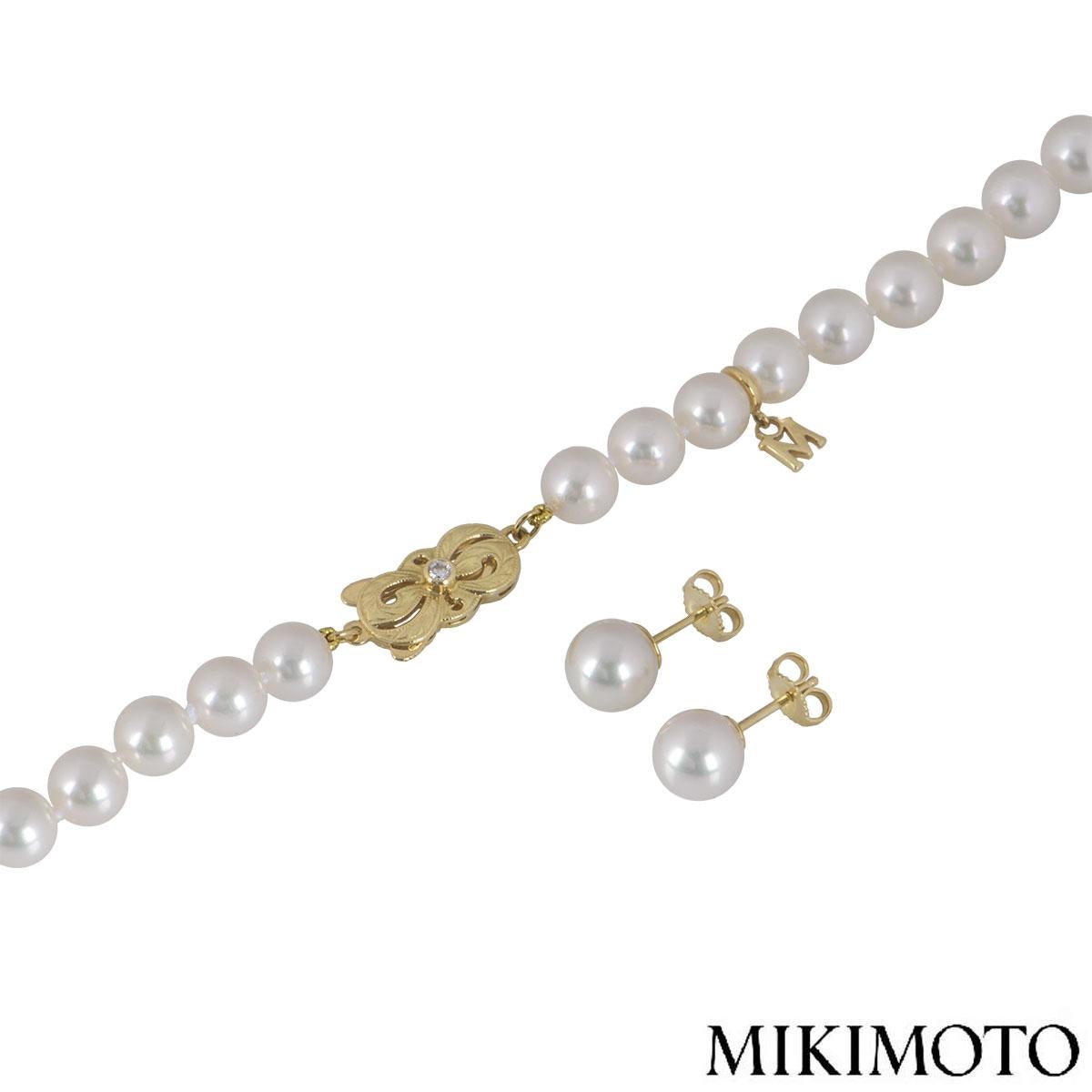 An 18k yellow gold diamond and pearl suite by Mikimoto. The suite features a necklace set with 56 Akoya cultured pearls measuring between approximately 7.00mm - 8.00mm with a single round brilliant cut diamond on the clasp approximately 0.04ct. The