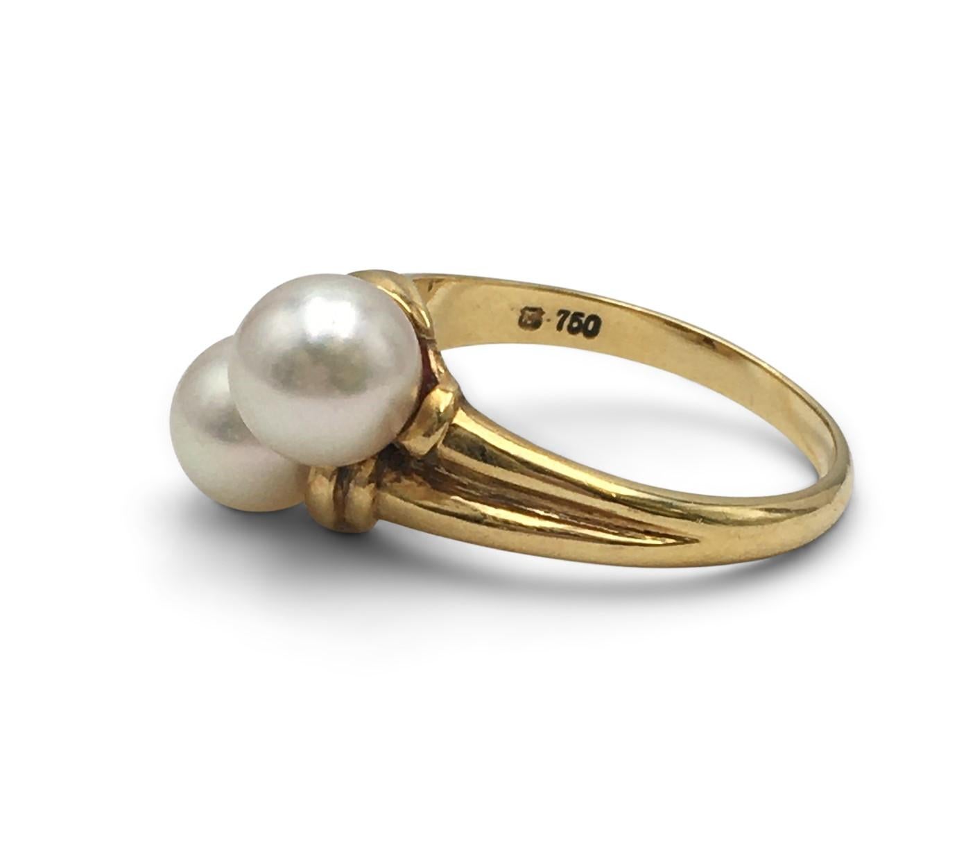 Authentic Mikimoto 18 karat yellow gold and south sea pearl bypass ring. The pearls measure 7mm each and are well matched in color and size. Signs of light wear present, no damage. Signed M, 750. Ring size 7. The ring does not come with original box