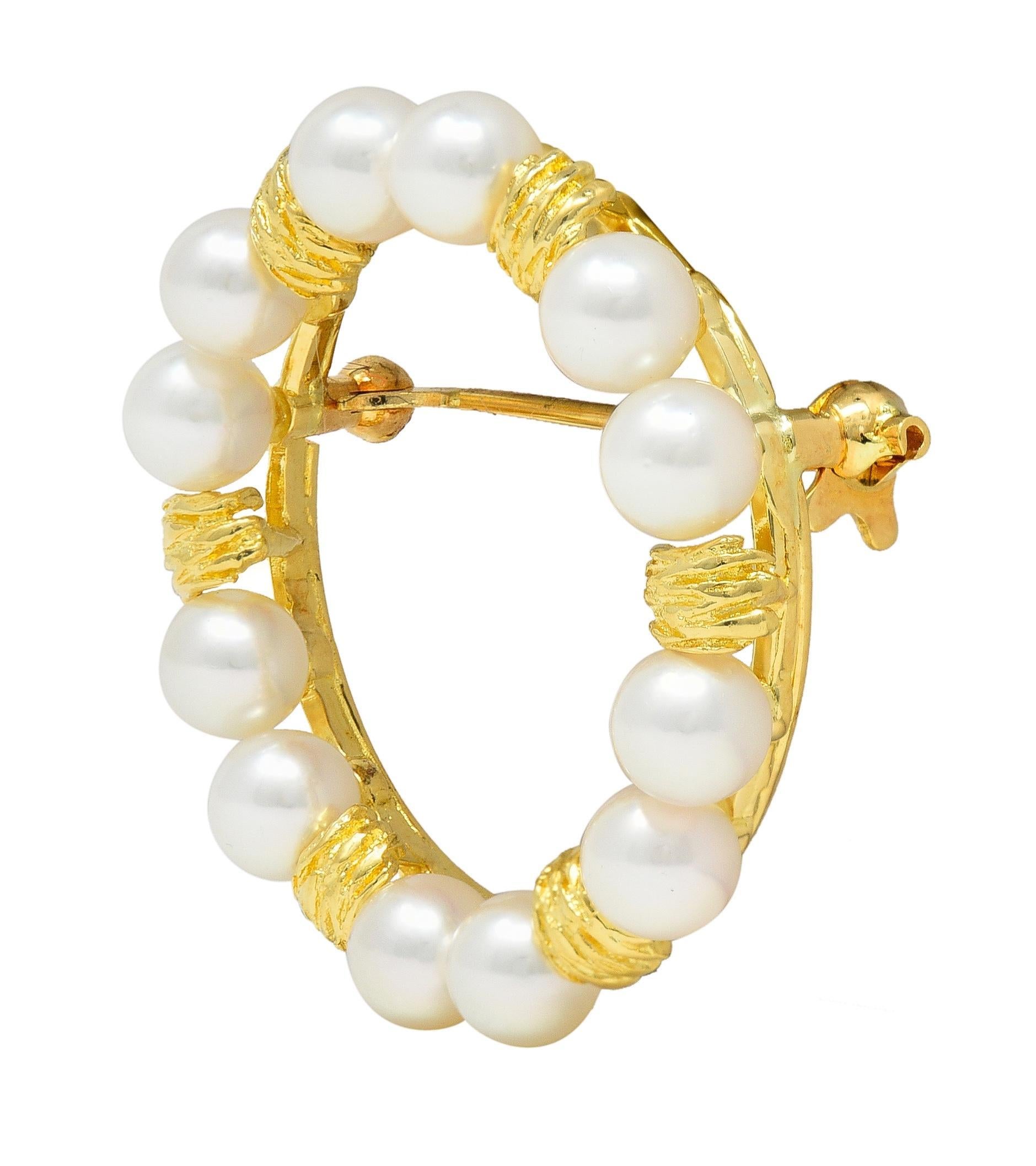 Designed as a circular wreath brooch featuring alternating round pearls and textured gold stations
Round pearls measuring approximately 5.1 mm
Pearls are cream in color with iridescence
Completed with hinged pin stem and locking closure
Stamped 750