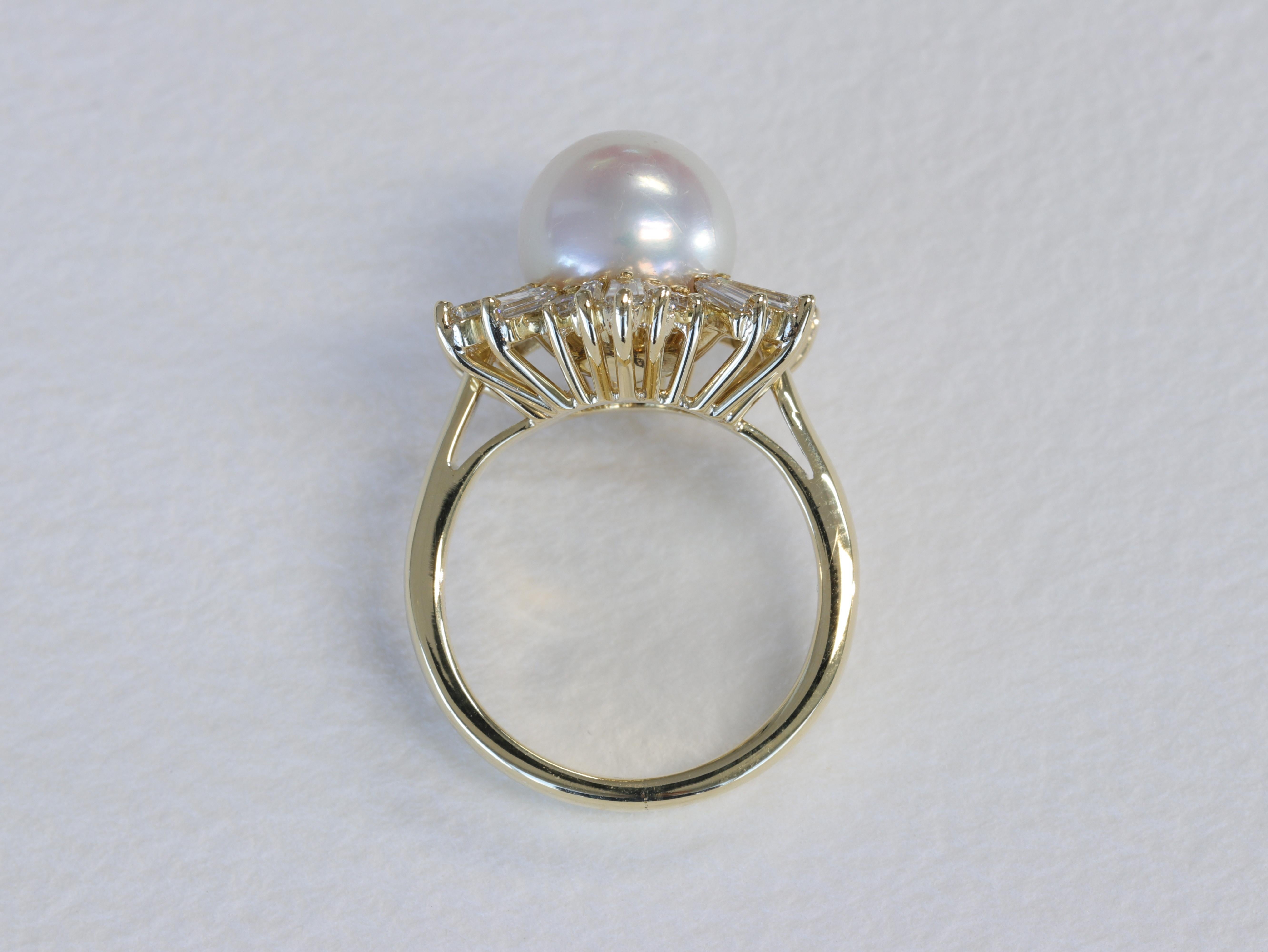 Cette spectaculaire bague Mikimoto à motif flocon de neige présente une belle perle ronde entourée d'un halo de diamants baguettes et ronds de taille brillante de différentes tailles et de qualité supérieure, dans une bague en or jaune 18 carats