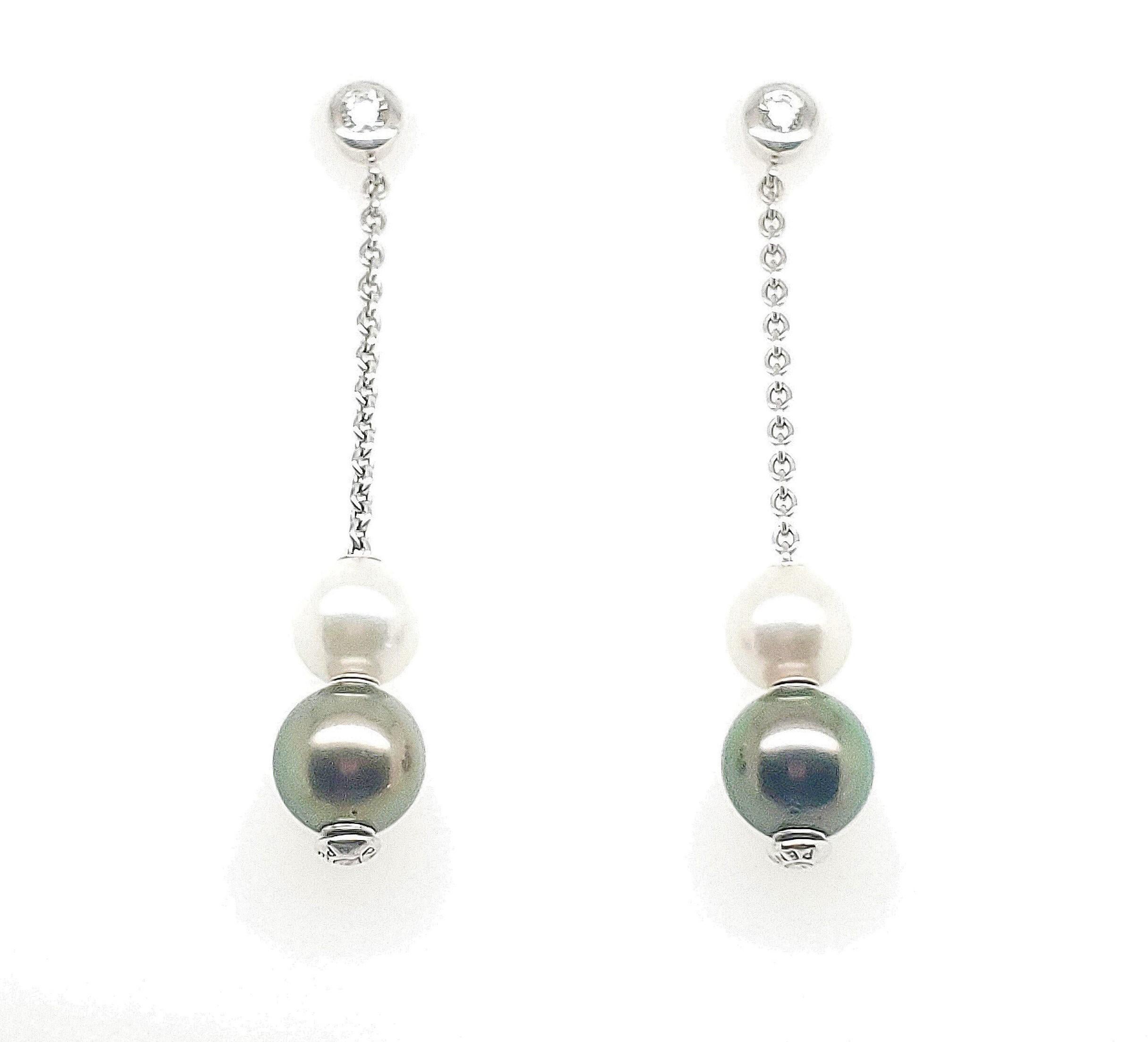 Authentic Mikimoto Pearls in Motion earrings made in 18 karat white gold with 2 round brilliant diamonds, 2 black south sea pearls measuring 8mm each, and 2 white south sea pearls measuring 7mm each.  The pearls can slide up or down on the white