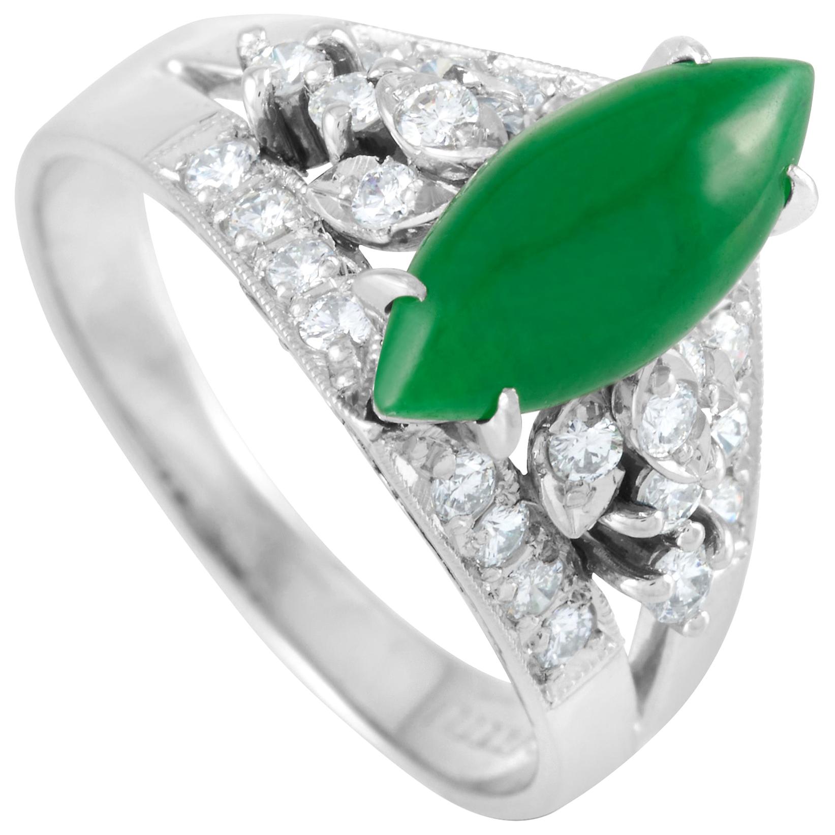 The Mikimoto Platinum 0.46 carat Diamond and Jade Ring has a regal presence and a vintage appeal. The platinum split shank band has its edges decorated with a channel of round diamonds framed by intricate milgrain borders. Sitting high atop on four