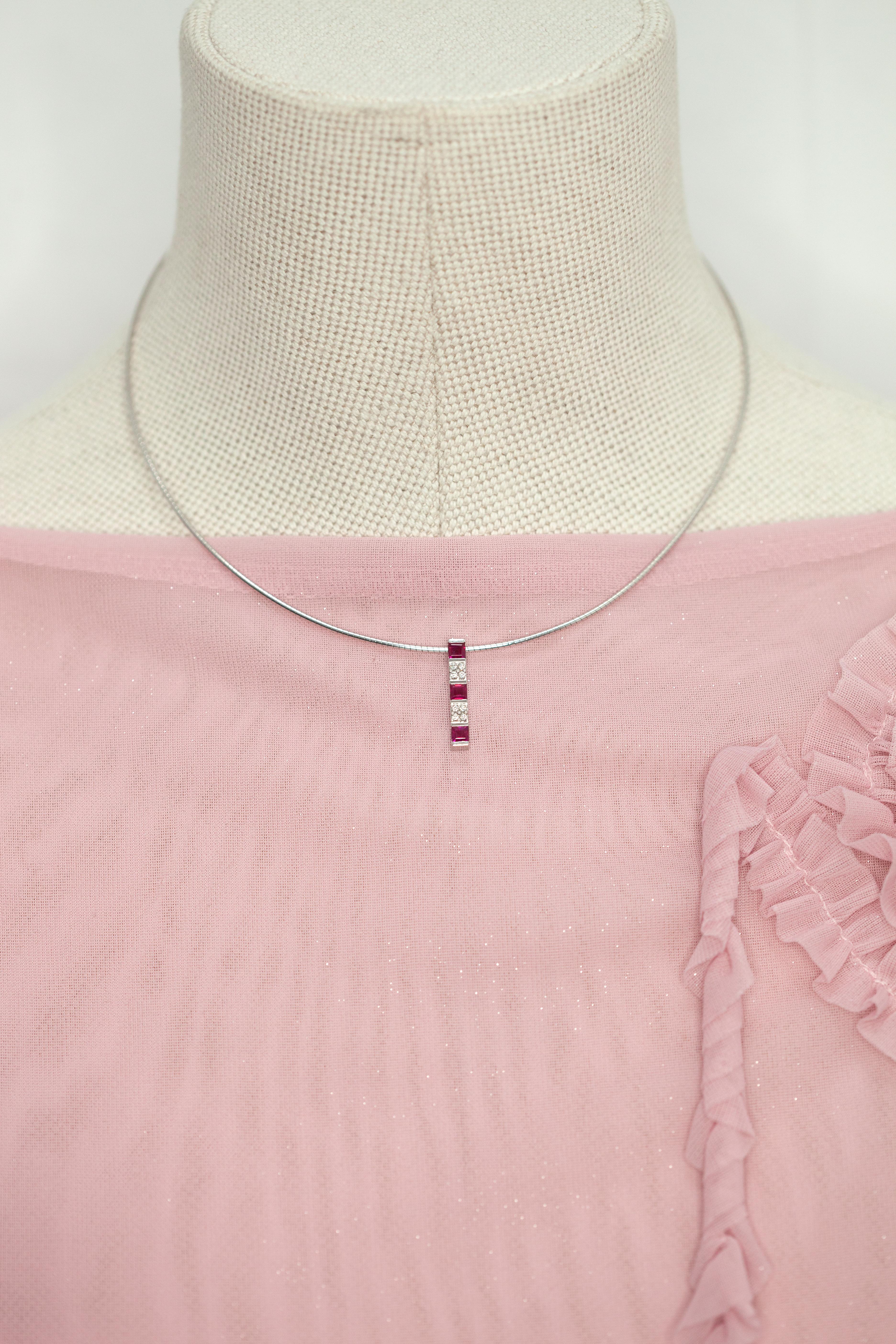 18K white gold ruby and diamond pendant necklace by the renowned Japanese jeweler MIKIMOTO, this elegant necklace features a sleek vertical bar pendant set with three vibrant square-cut rubies, interspersed with two sections of brilliant-cut