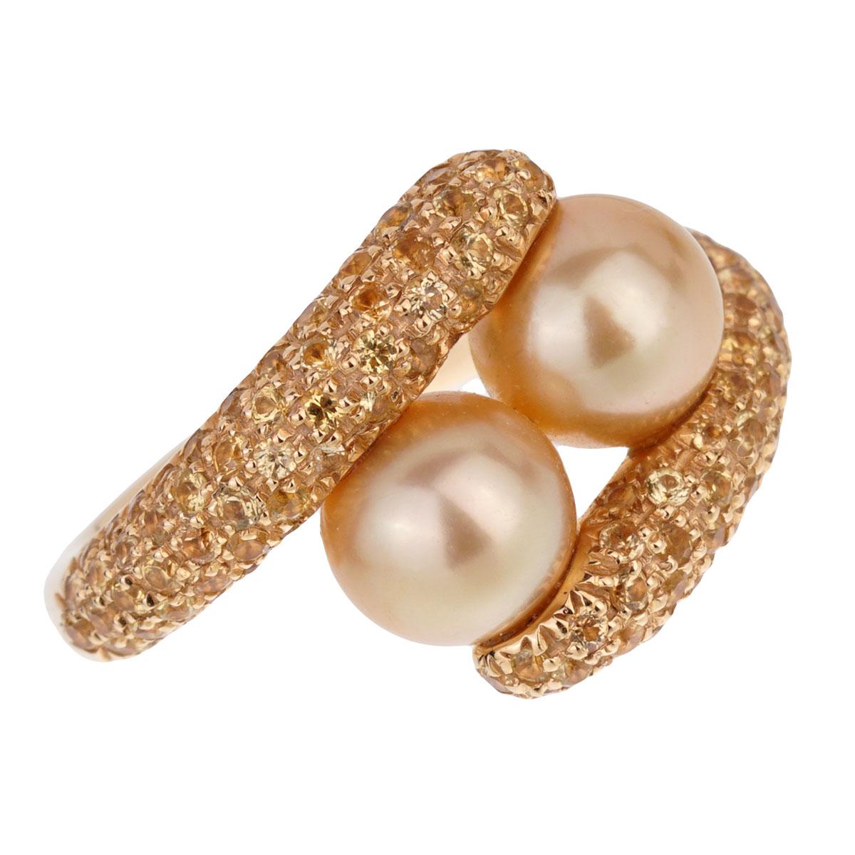 A chic bypass ring by Mikimoto showcasing 2 8.5mm pearls encased with yellow sapphires in 18k yellow gold. Size 6 (Resizeable)