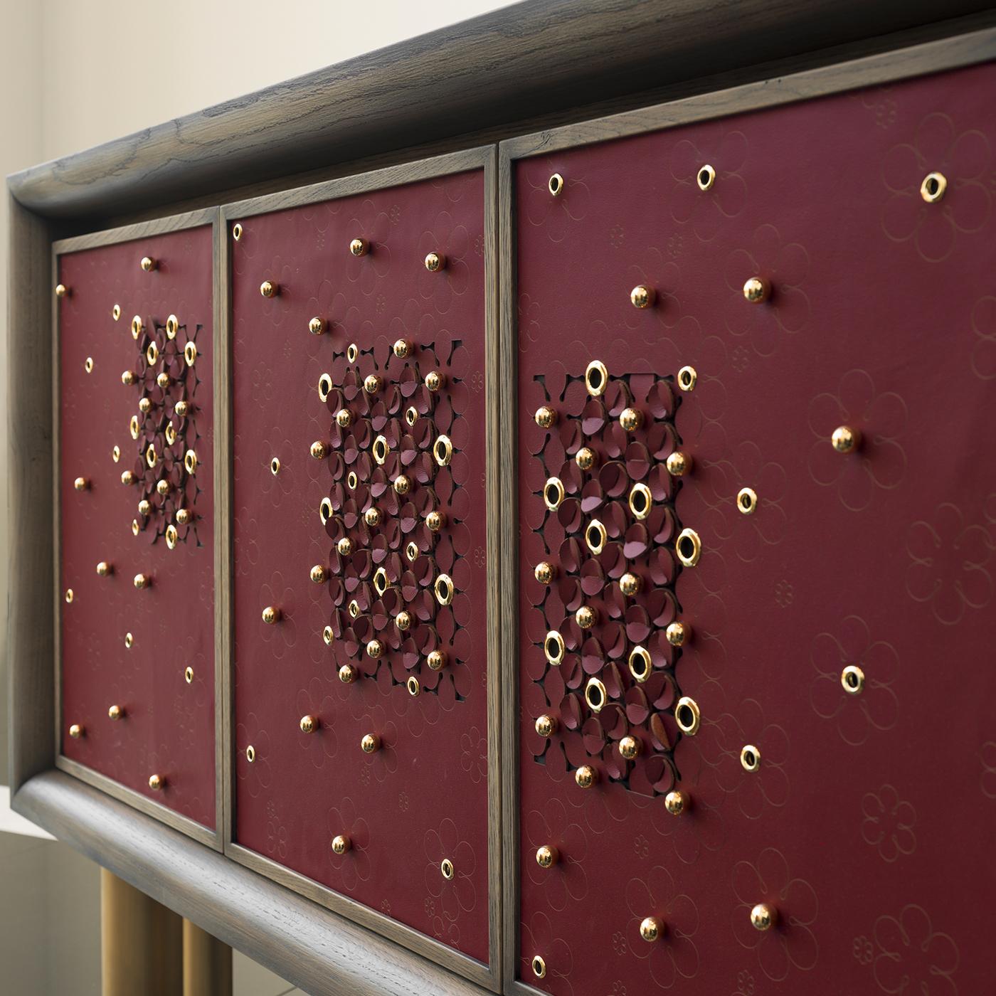 Lying in the intersection of furniture design, art and fashion is the Mila Full Spring Blossom Sideboard from Chiara Provasi's Couture Collection. Handcrafted in oak with a gray finish, the sideboard on bronze legs is accented with laser-cut red