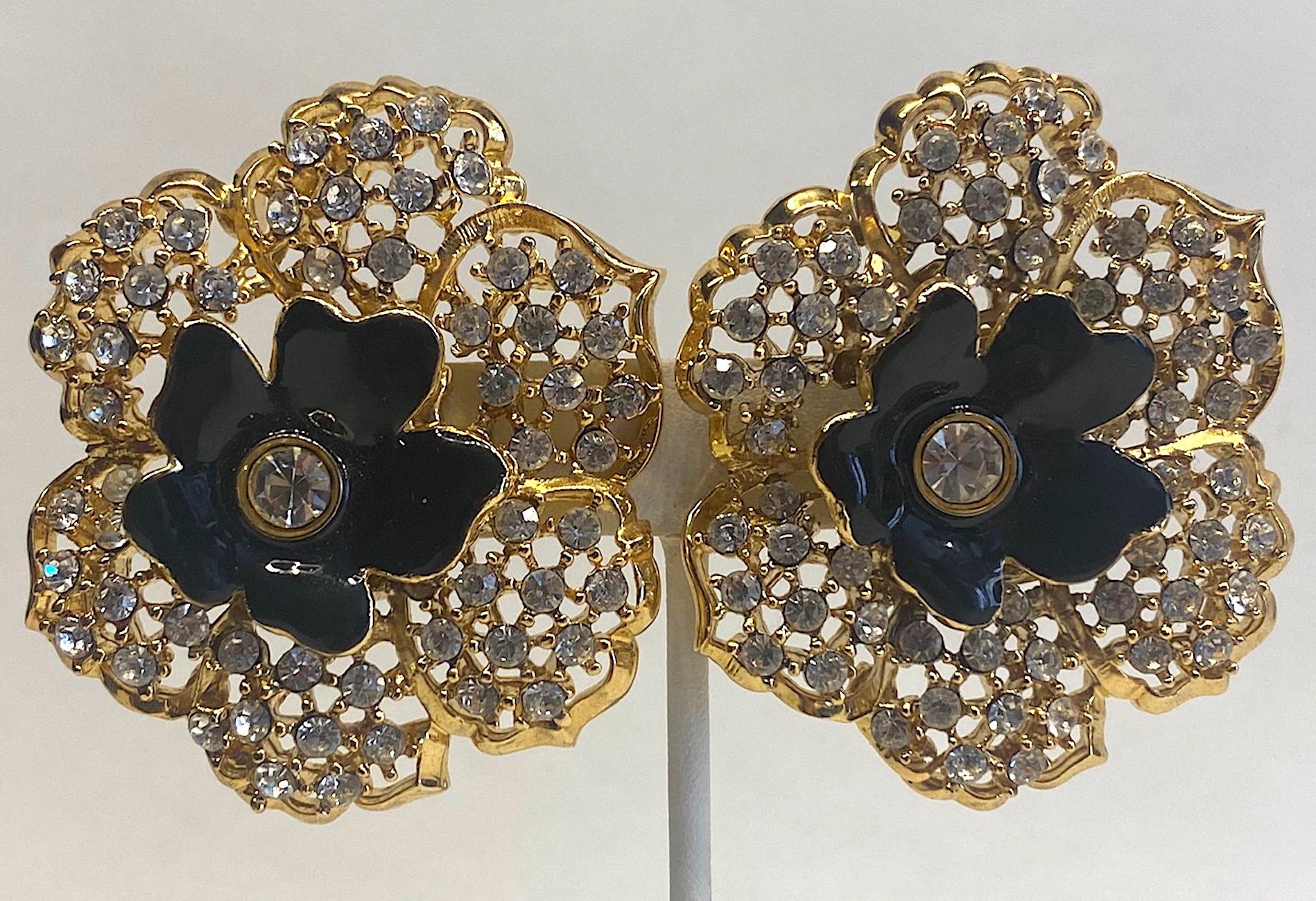 A truly stunning and like new condition pair of Mile Schön Milano flower earrings. The earrings have an open work design on the petals and set with round rhinestones. In the center is a smaller 1 inch diameter black enamel flower with large central