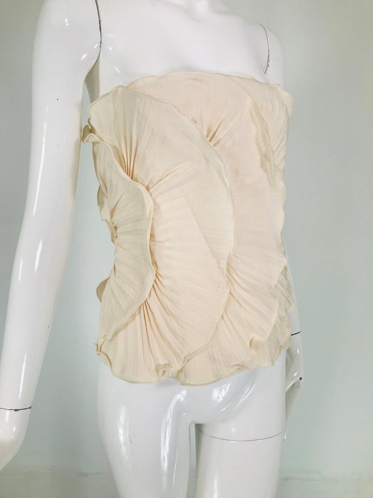 Mila Schon ivory bustier plisse silk 1980s, unworn with tags size 40. Beautifully constructed bustier with pleated half circles that remind of petals that circle the torso. The garment is boned and lined with white silk, it closes at the size with a