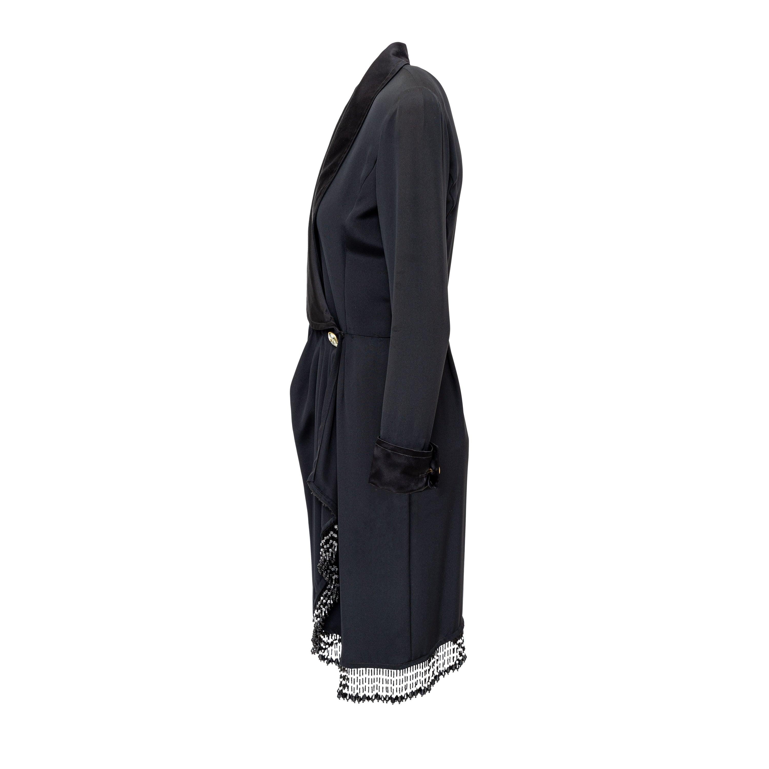 Effortlessly elegant, the Mila Schön midi dress captures the essence of '70s fashion. This satin wrap dress features a precious lapel collar and a hem bordered with black teardrop beads. Its asymmetrical drape and jewel buttons at the waist and