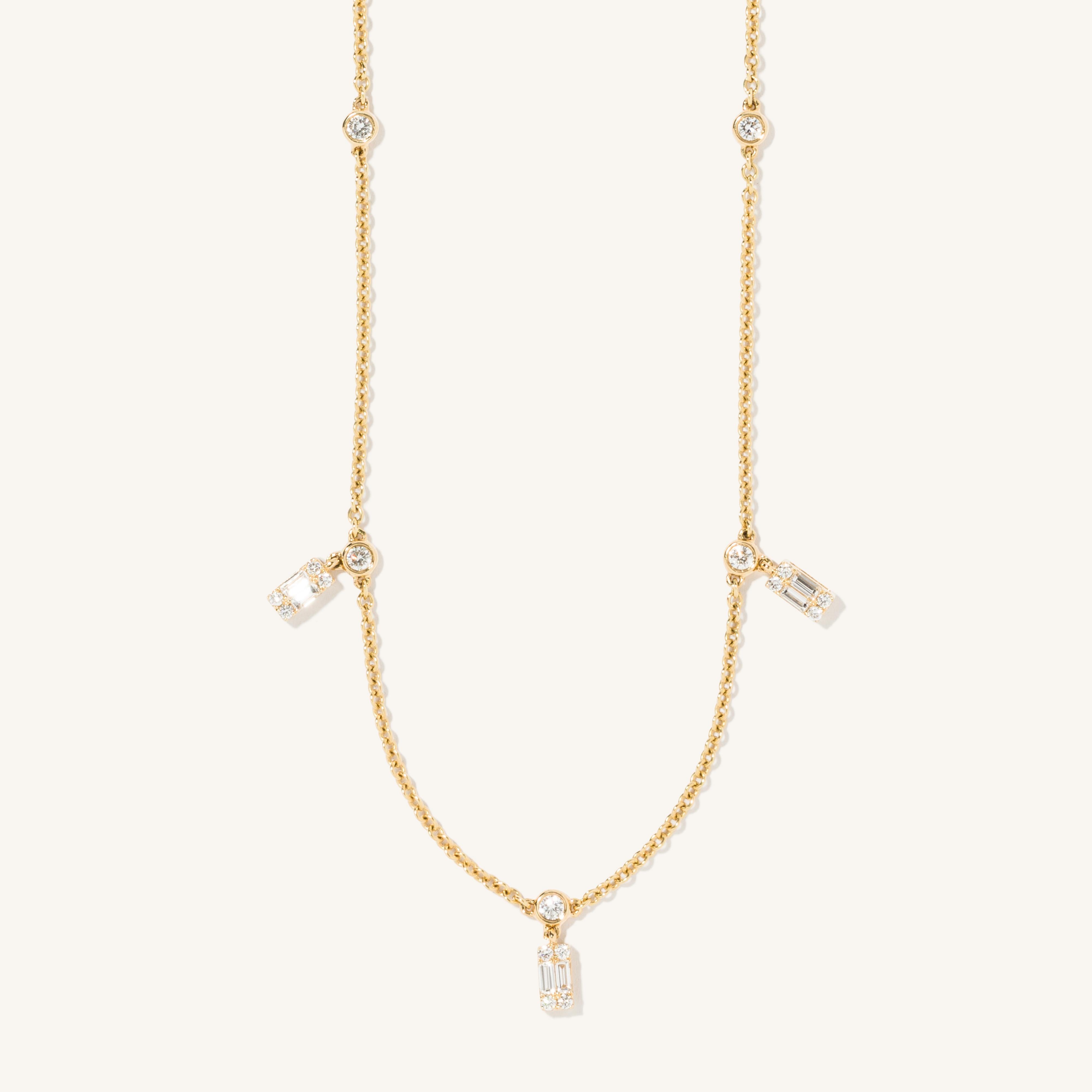 This classic necklace uses three round-cut diamonds to highlight two 0.5 carat baguette cut diamonds. The dainty 18 karat yellow gold chain helps make this chain an everyday essential you'll never want to take off. 

Necklace length: 40 cm.