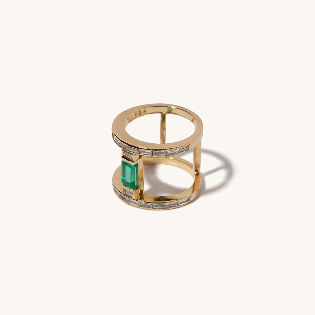 Milamore's signature ring features a beautiful 0.8 carat emerald situated between two diamonds. Our signature design also features 0.92 carat baguette cut diamonds that breathtakingly pave along the perimeter. Crafted with 18 karat yellow