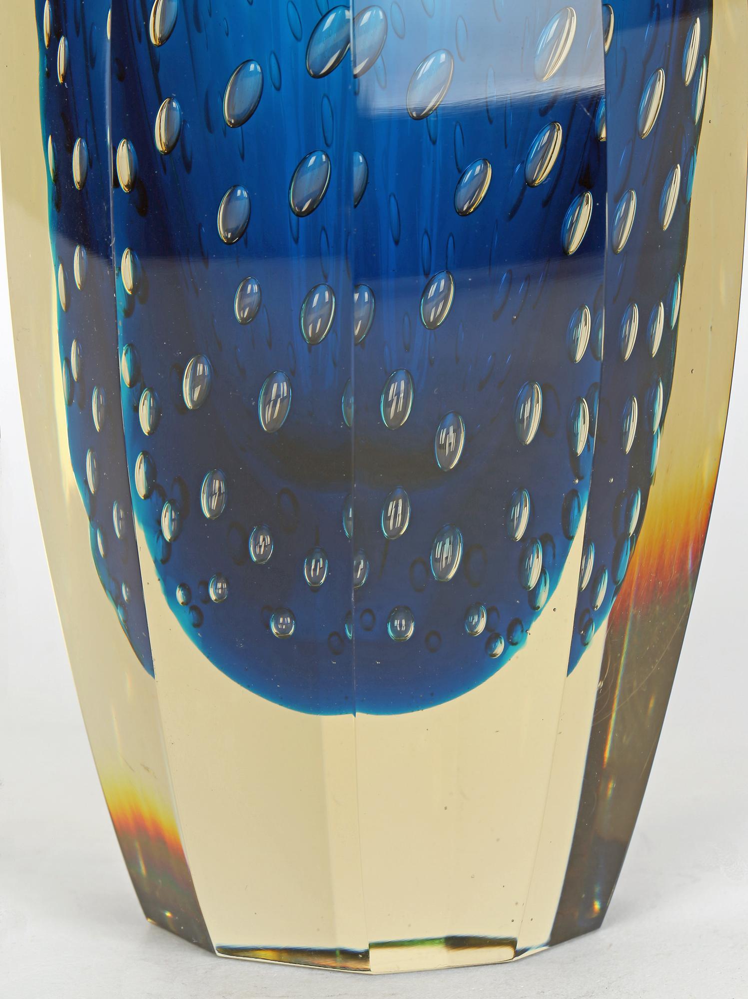 A wonderful, large and very heavy Czech mid-century blue bullicante cased art glass vase designed by Milan Metelak for Harrachov and probably dating from around 1960. The vase is of tall rounded shape with ten flat vertical panels around the side