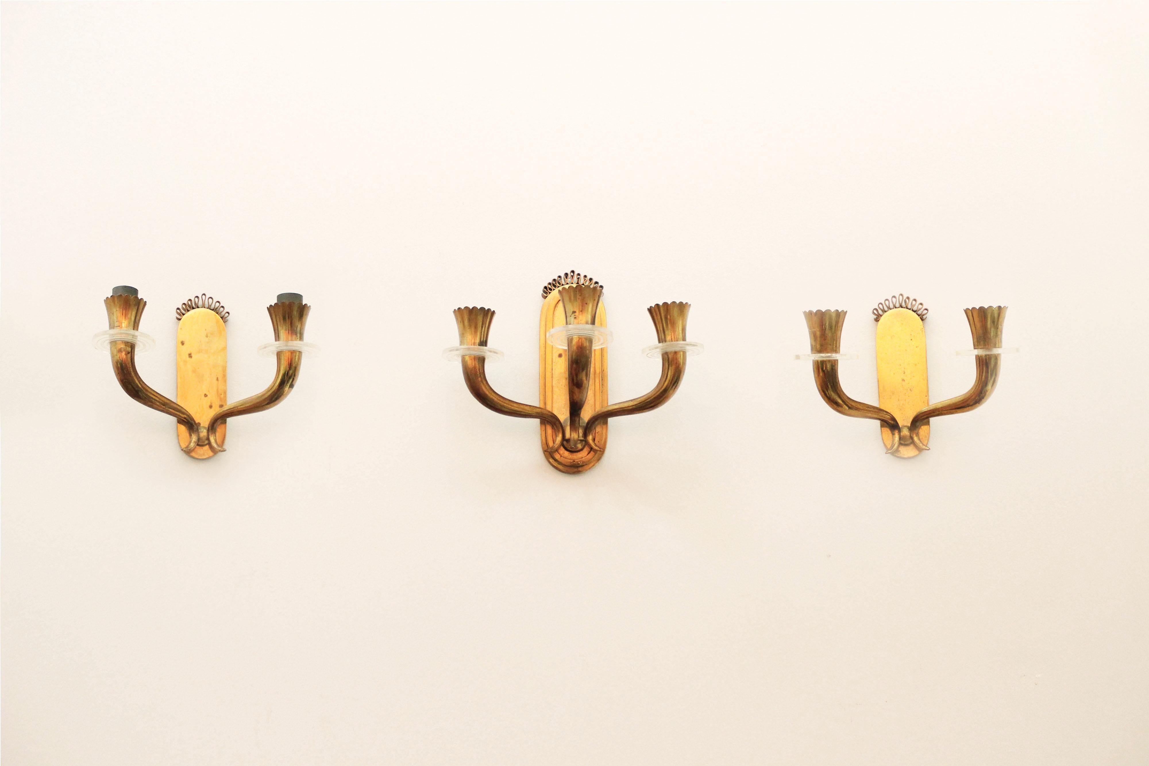 Set of three gilt brass sconces by Gio Ponti, 1940s. They need polishing. The two-light sconces are 13 cm deep, the three-light one is 15.5 cm deep.
European socket (up to 250V)