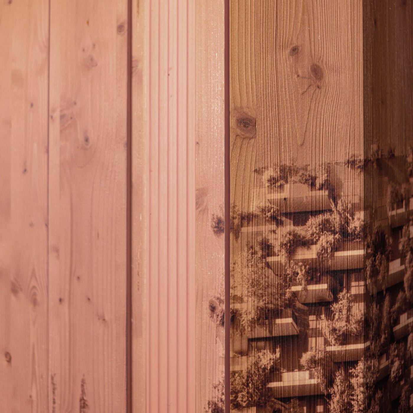 Une séparation de pièce en bois peint dont la face extérieure, apparemment solide, s'ouvre en persiennes par simple pression, disparaissant presque. Chaque panneau a deux faces : la principale contient une partie de la vue urbaine, tandis que le
