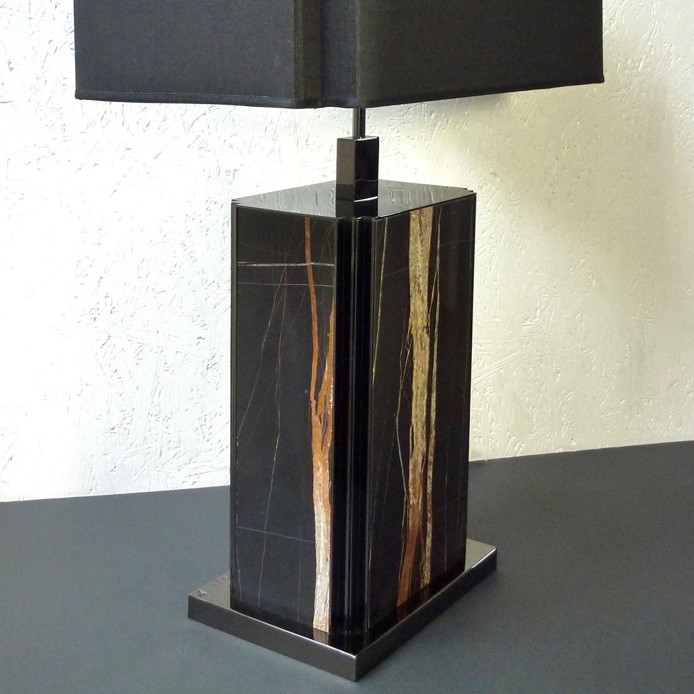 The rich white and golden brown veining of the black Sahara Noir marble take center stage in this stunning table lamp that will be a supremely luxurious addition to a console and side table in a modern living room, bedroom, and office. Sleek and