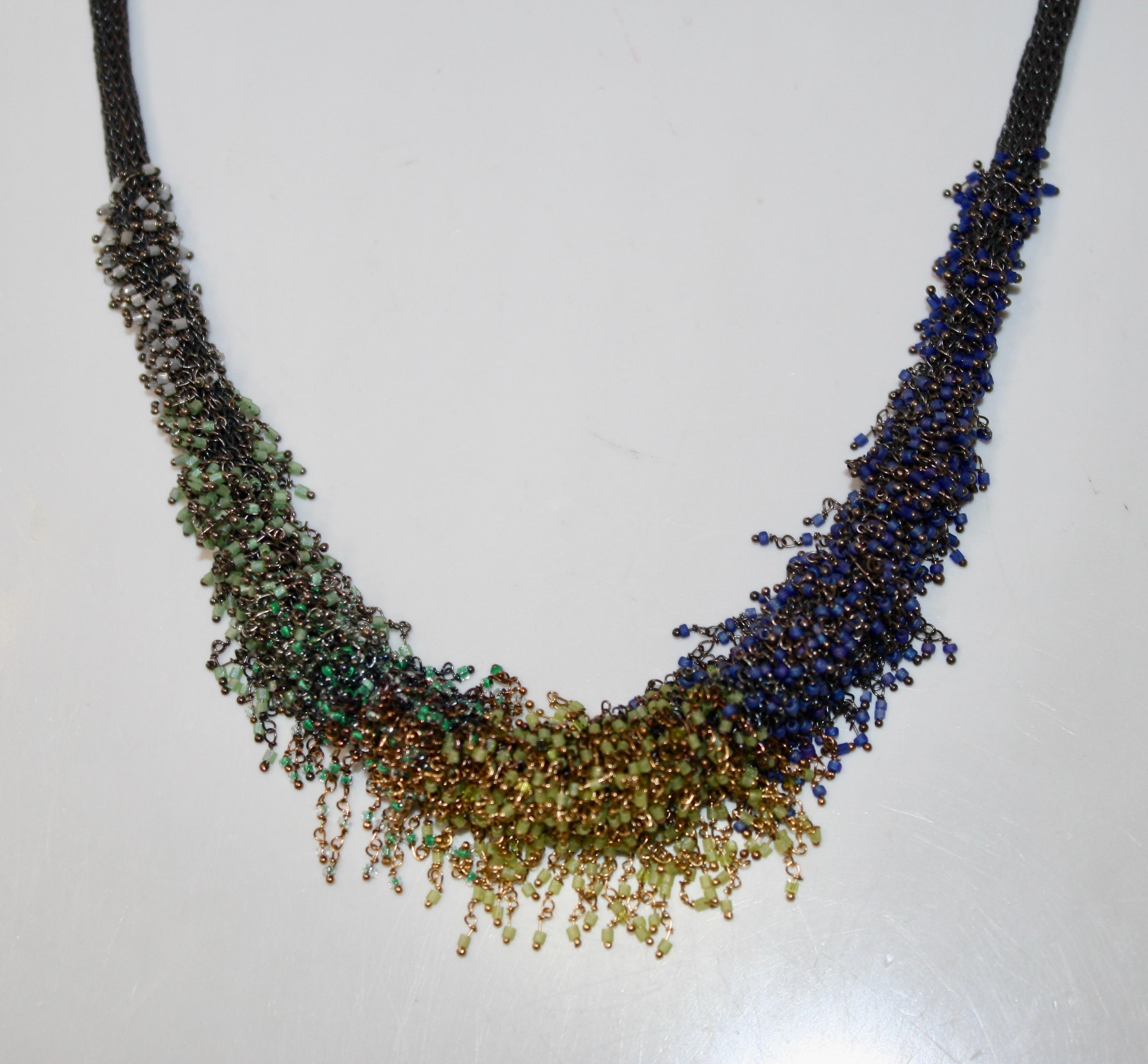 This beaded necklace by Milena Zu will lift your outfit to the next level.
This edgy Milena Zu mesh necklace is made of fine brass wire which has been partly silver plated and oxidised to an almost black colour. It is decorated with hundreds of tiny