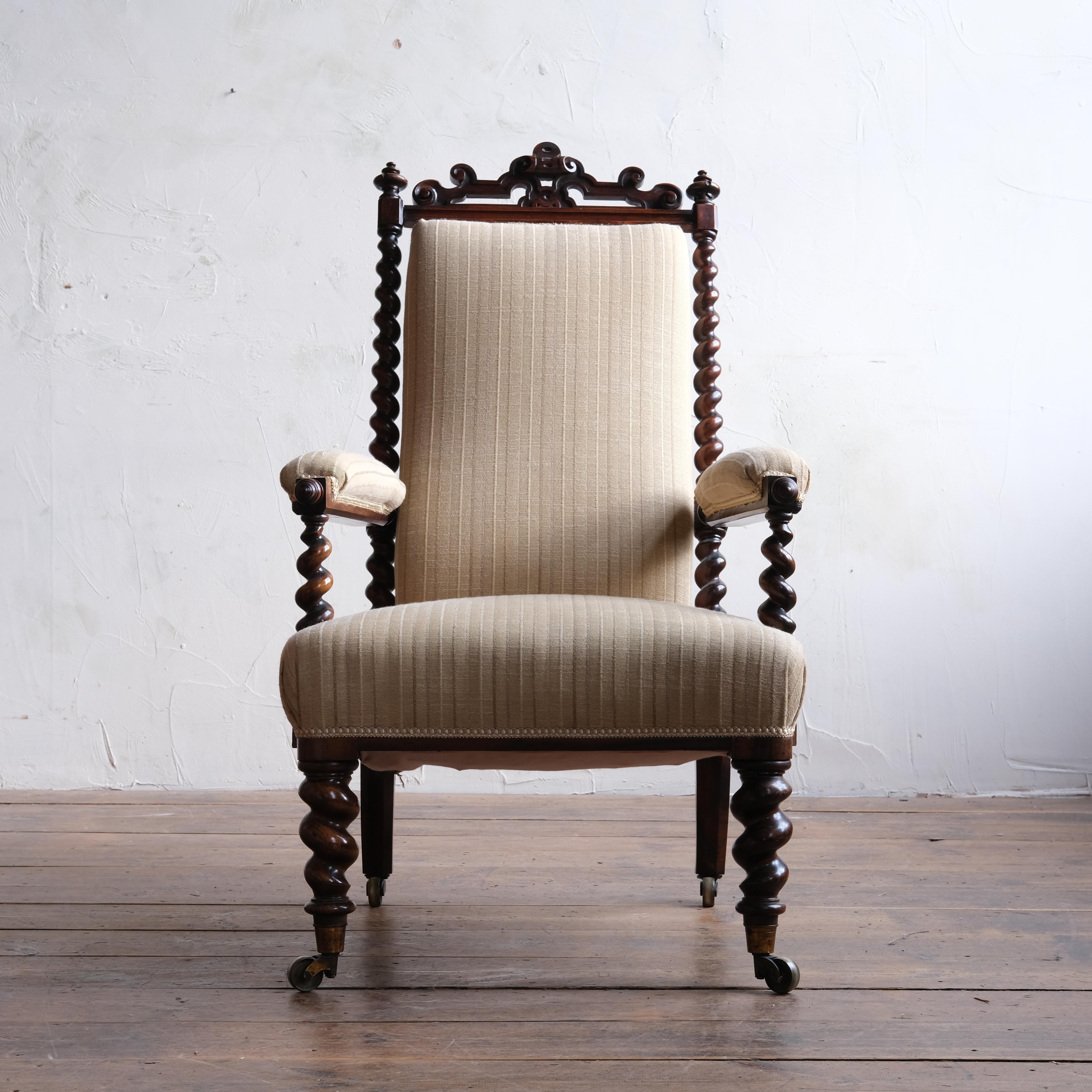 A quality 19th century open armchair by Miles & Edwards. Constructed from nicely figured solid rosewood and raise on barley twist legs and show frame with the original brass casters. Structurally in solid order with the beige striped linen type