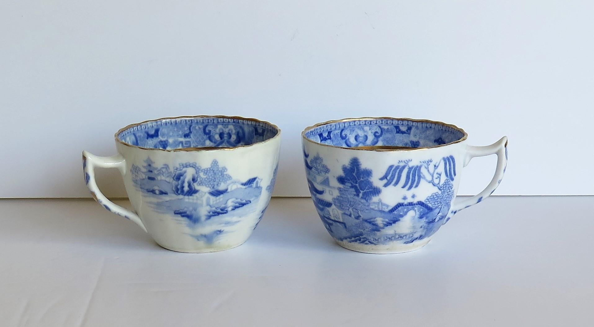 These are pair of porcelain blue and white, hand gilded tea cups made by Miles Mason (Mason's), Staffordshire Potteries, England around the turn of the 18th century, circa 1805. 

The cups are well potted with a bute shape, slightly fluted