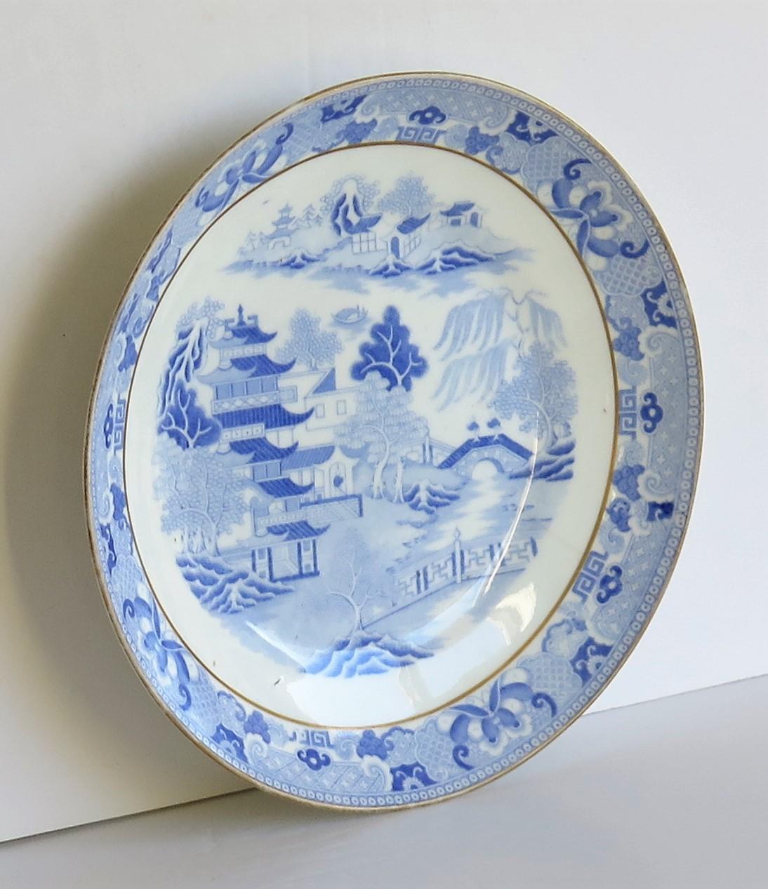 This is a porcelain blue and white, hand gilded plate or dish made by Miles Mason (Mason's), Staffordshire Potteries, England, dating to circa 1810. 

The plate is well potted on a low foot.

It is decorated in the under-glaze blue printed