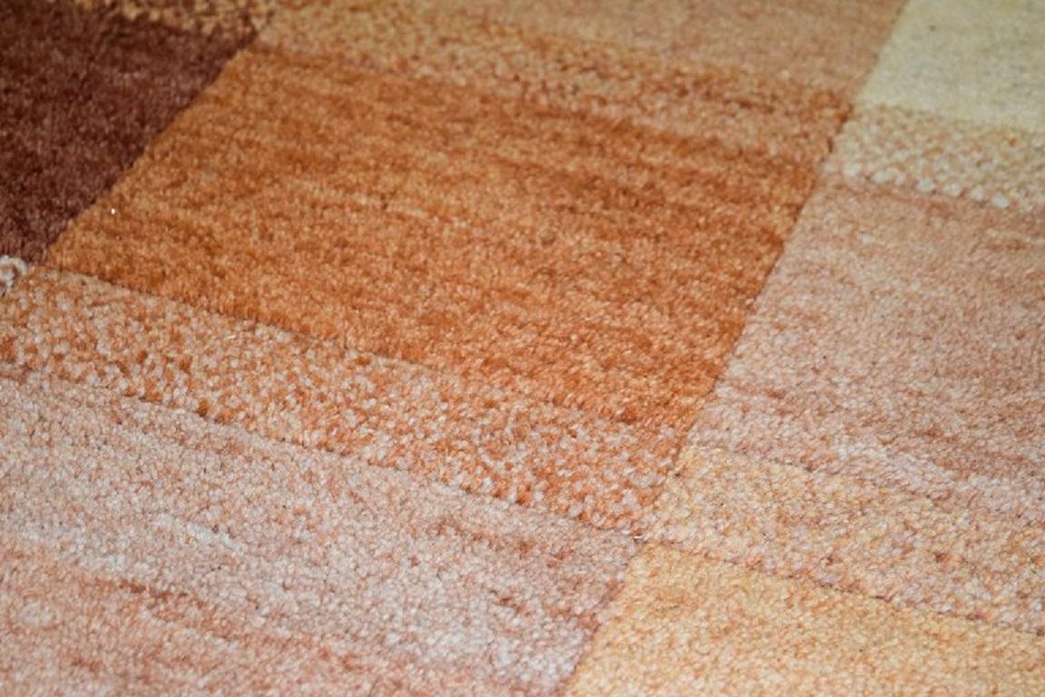Scandinave moderne Milford, Suède, tapis en pure laine. champs géométriques dans des nuances rouges, oranges et blanches en vente