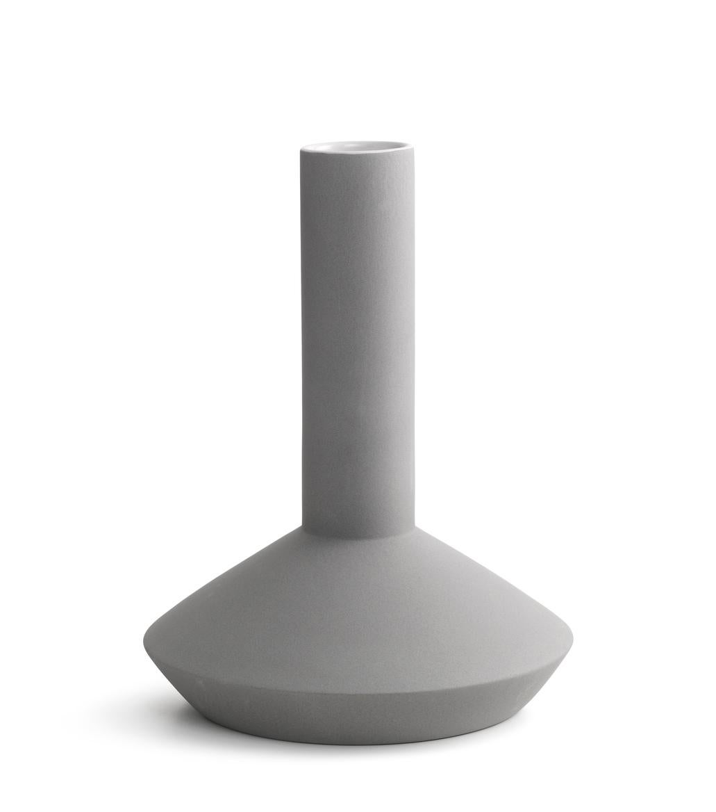 Vase designed by Milia Seyppel in 2011.

Industrial beauty. Inspired by industrial architecture, machinery, and tools for mass fabrication. Straight lines, sharp edges, clear shapes. Wrapped in a velvety soft surface reminiscent to concrete or