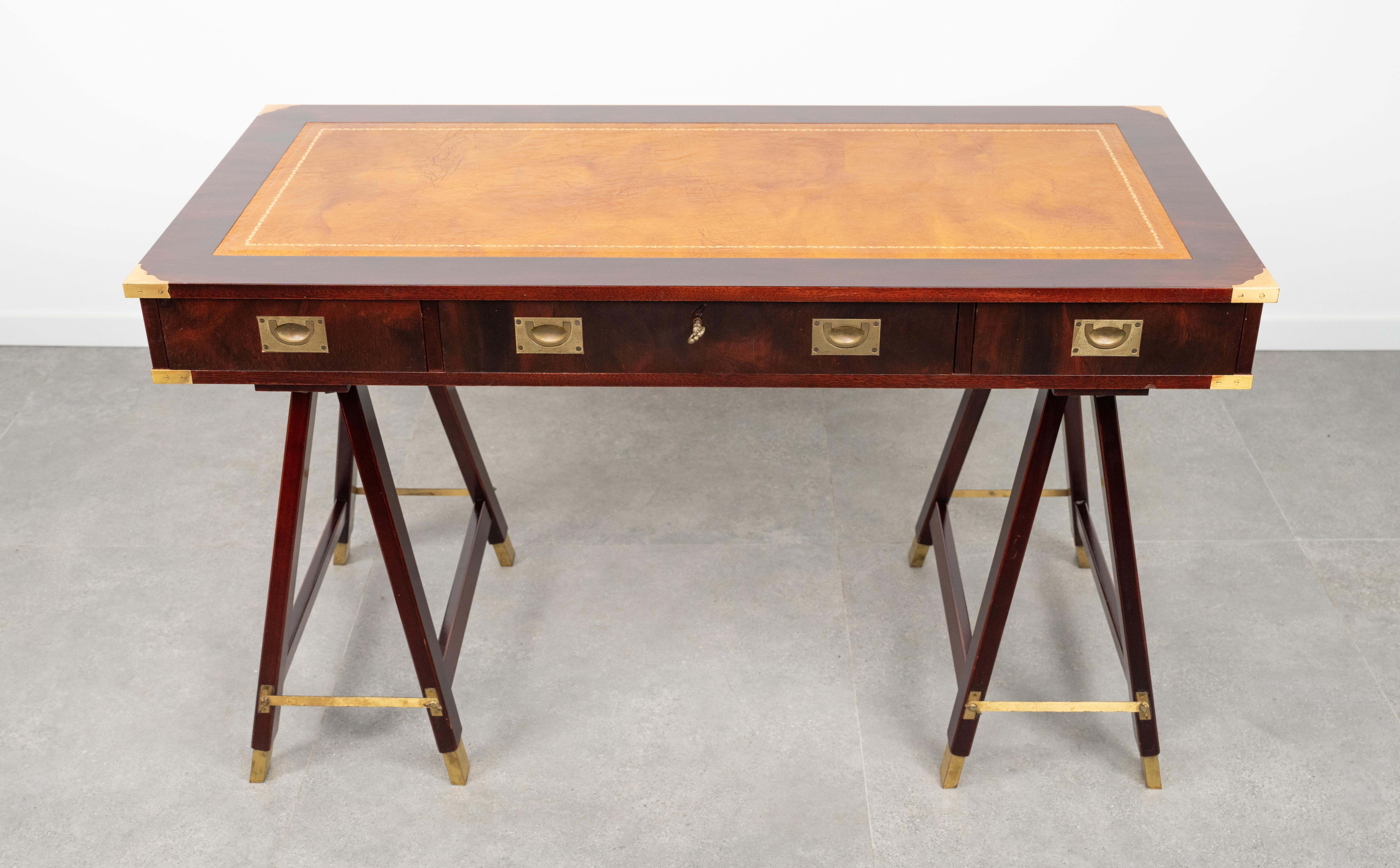 Amazing desk table  in the antique military campaign style in wood, brass and leather top with three drawers by Sea Line Orvieto.

Made in Italy in the 1960s.

It has three good size drawers with brass handles and fixtures.

The trestle base is a