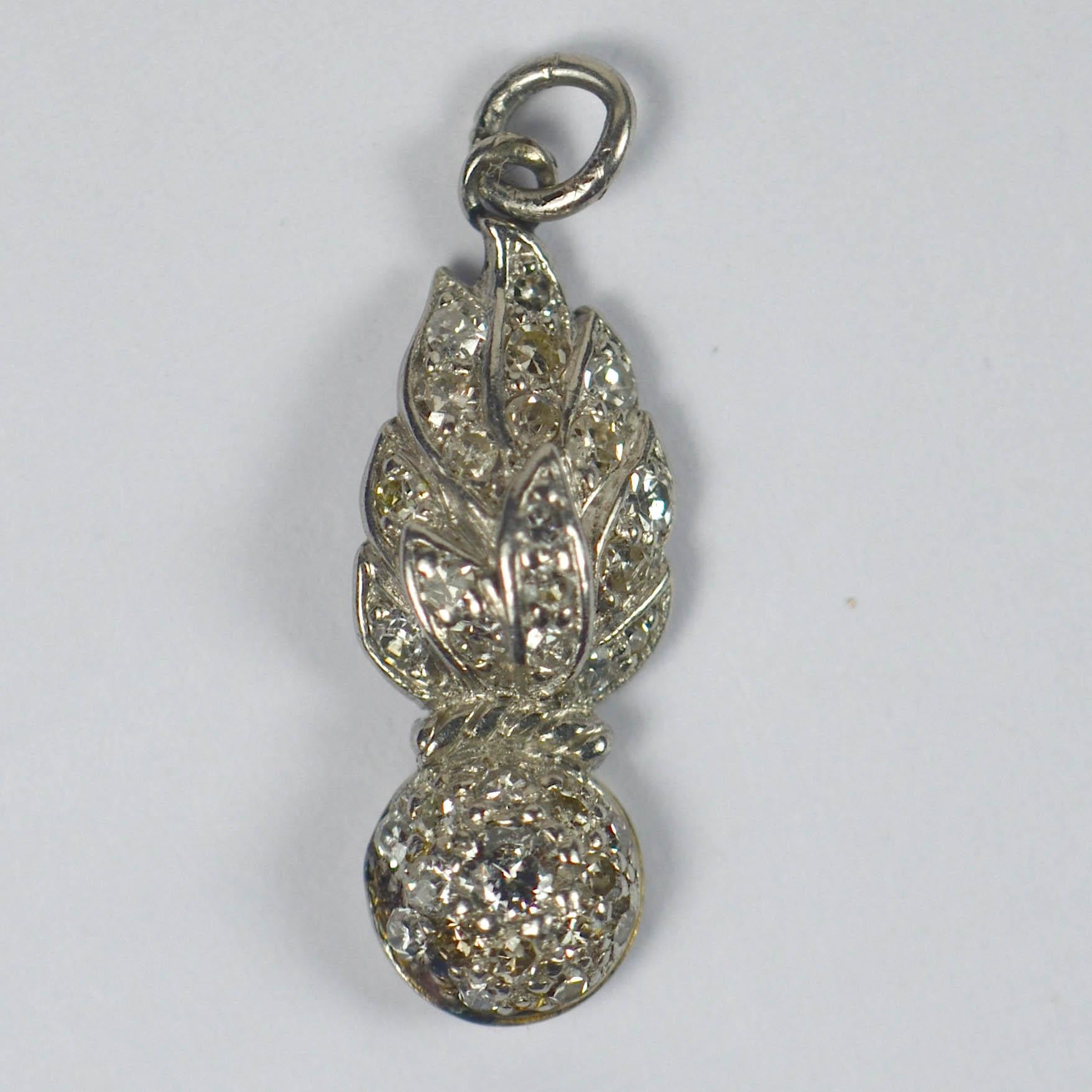 A white gold and diamond set charm pendant depicting the Grenadiers military emblem.

3/4