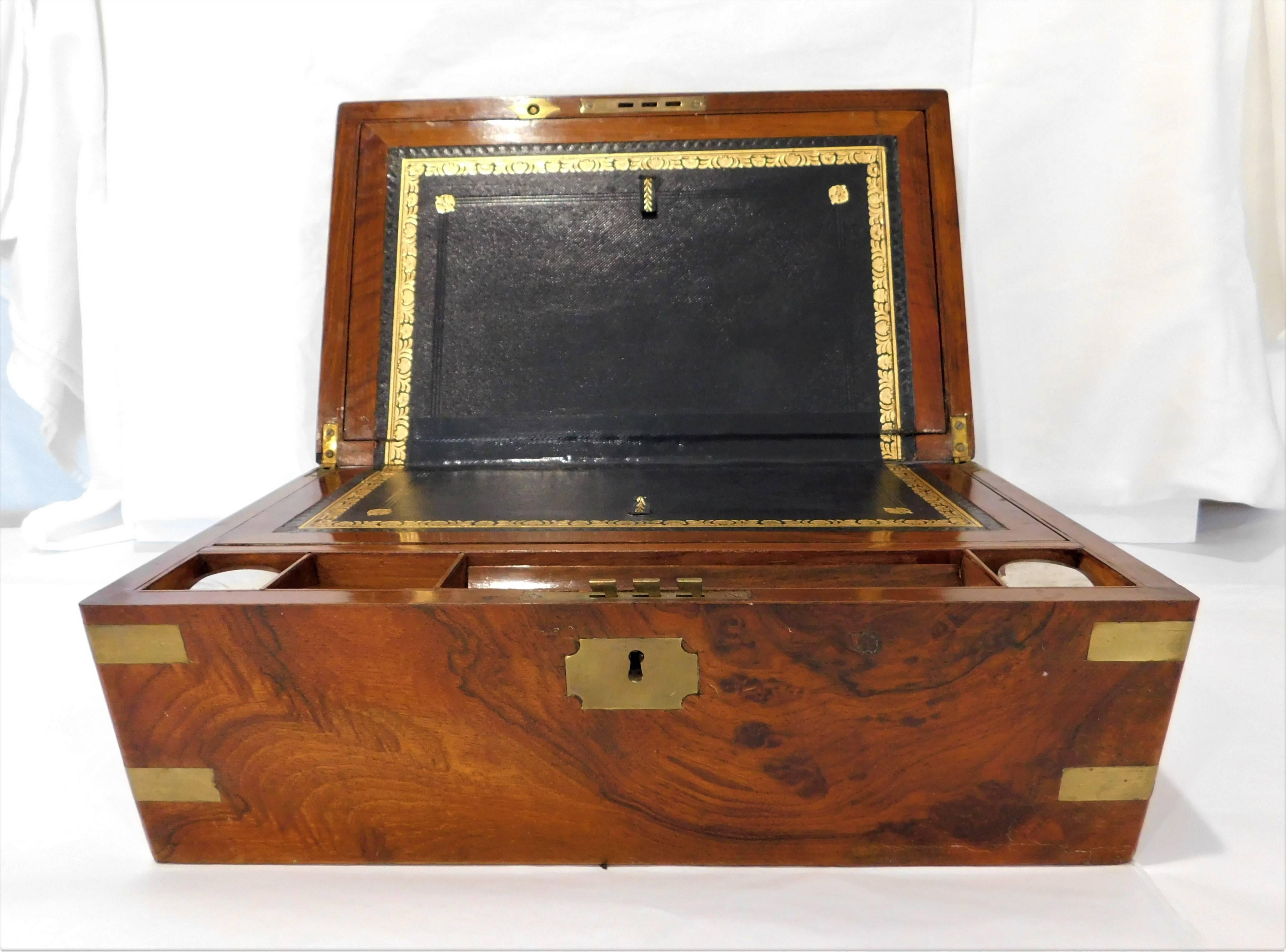 This military style Victorian lap desk writing slope has multiple internal compartments including a secret drawer! Also two glass ink wells. It is made with walnut with brass accents.

Writing slope
As an antique the lap desk is a smaller variant