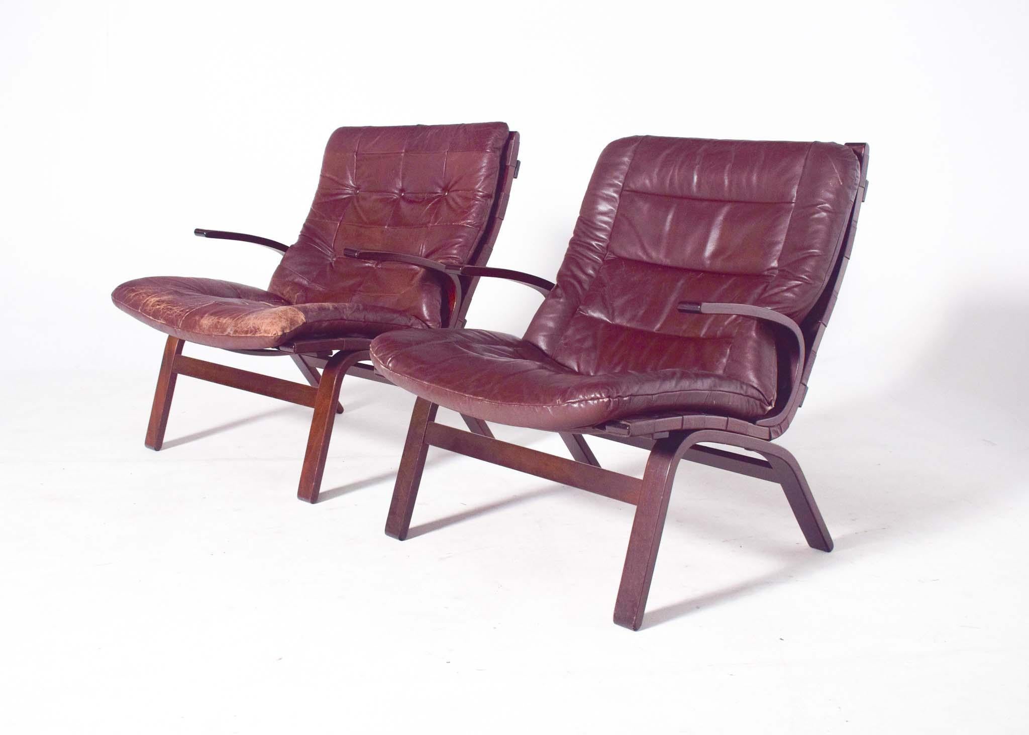 Pair of Miljo Range armchairs, brown leather cushions on beech plywood frame, 1960s. Fantastic chairs with curved wooden frame with armrests and upholstered seat covered in brown leather. Very comfortable due to its construction and the touch of