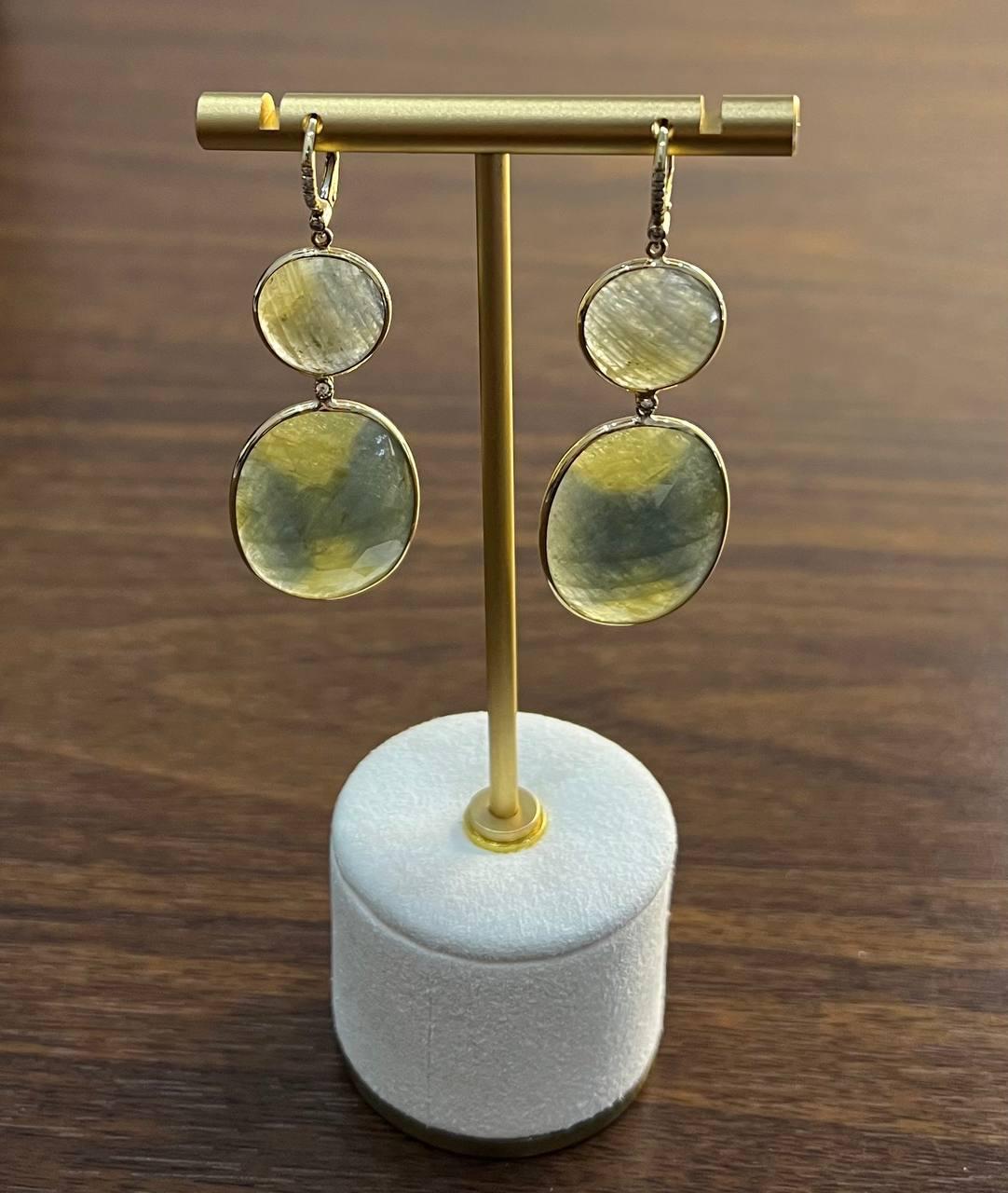 Elegant drop earrings featuring two-tiered, oval-shaped stones with a subtle blend of green and yellow and cloudy milky white hues. The stones are set in a sleek, minimalist 14K yellow gold frame, allowing the natural beauty of the stones to shine.