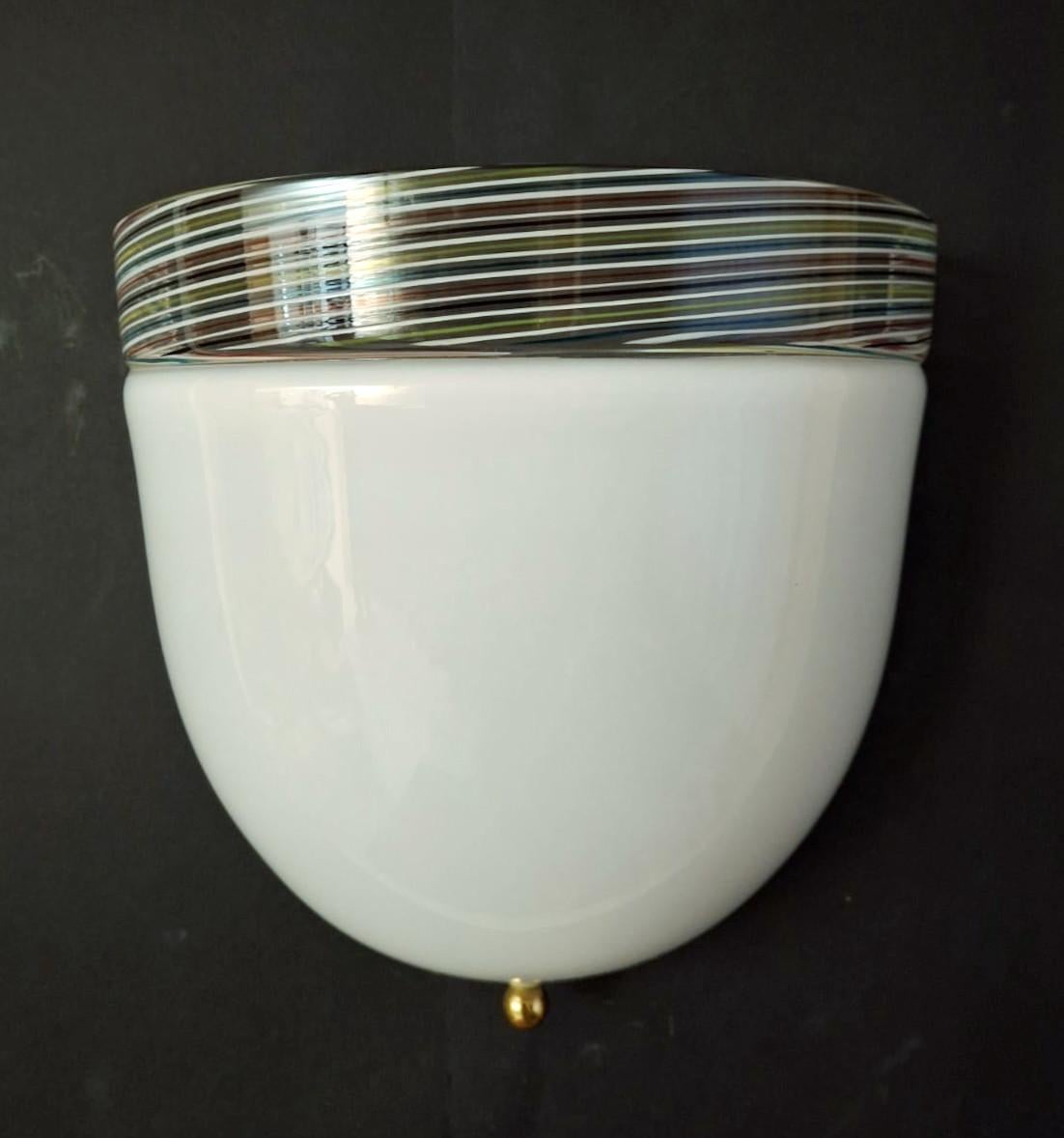 Aplique de pared italiano vintage con pantalla de cristal de Murano blanco lechoso y borde de cristal transparente impregnado de estrías multicolores / Fabricado en Italia hacia la década de 1960
Medidas: alto 9 pulgadas, ancho 9,5 pulgadas,