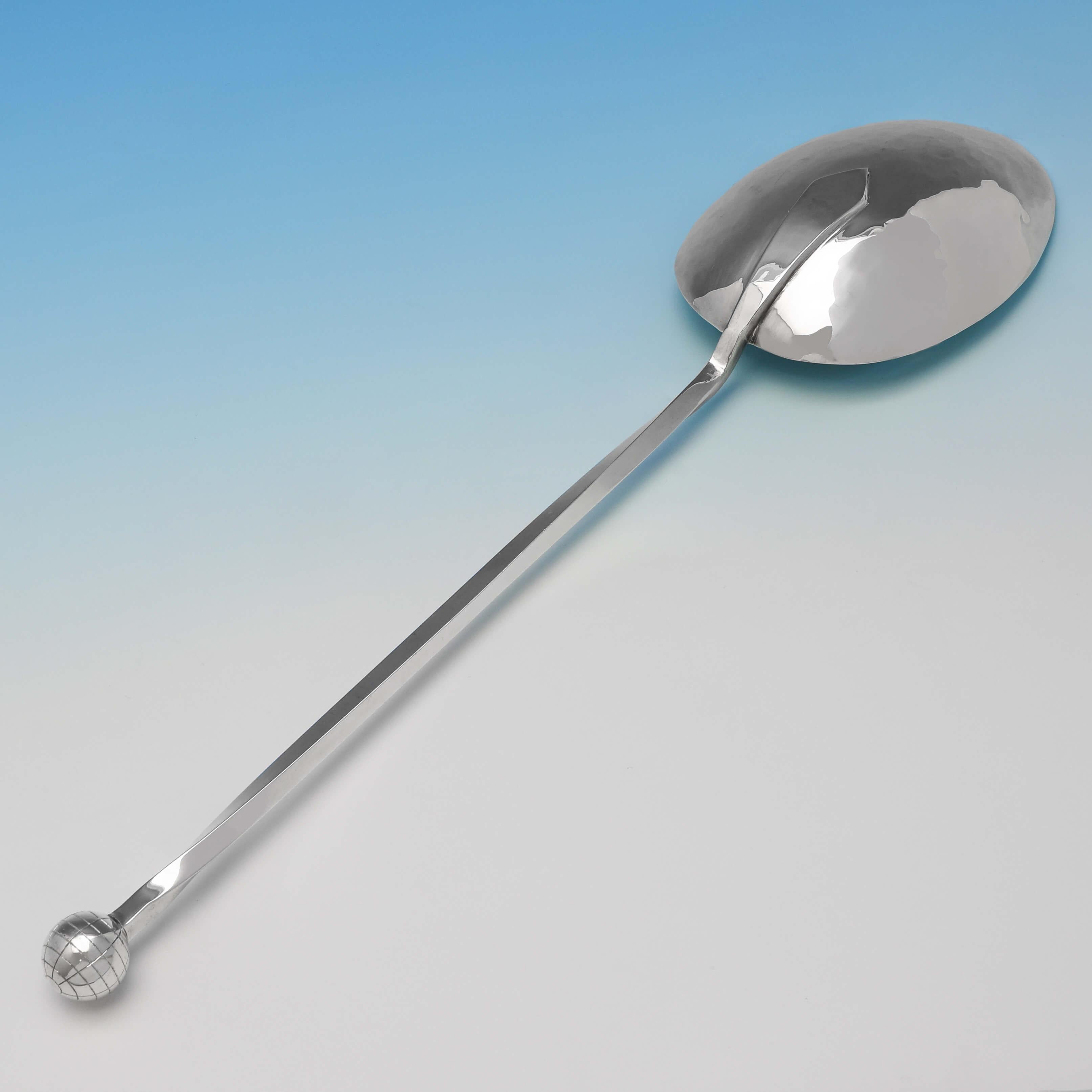 Hallmarked in London in 2000 by Ramsden & Roed, this striking and large, sterling silver basting spoon, is modernist in design, and features a hammer finish to the bowl, a twisted handle and a globe finial. The basting spoon measures 14.5