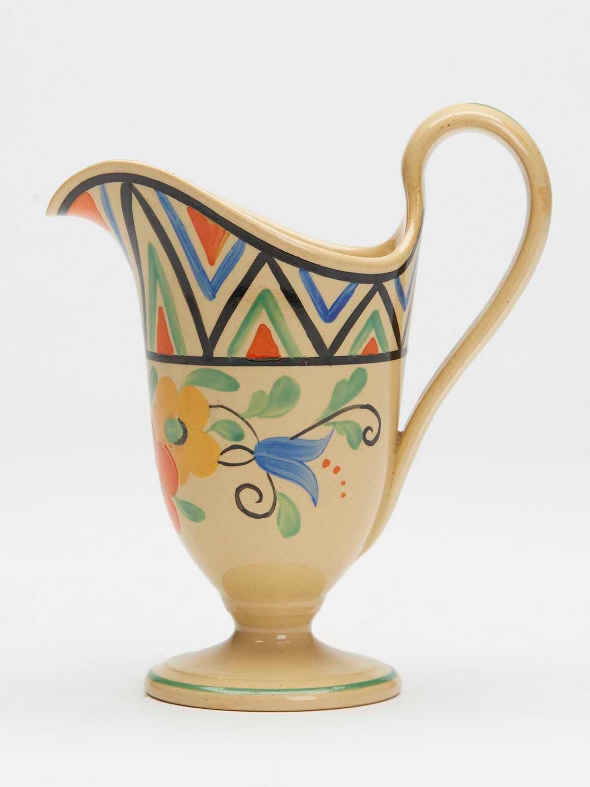 Une très belle et élégante cruche à crème Art déco Wedgwood peinte de motifs floraux, réalisée par le célèbre designer Millicent (Millie) Jane Taplin (britannique, 1902-1980) et datant d'environ 1930. 

Millie était une peintre en céramique renommée