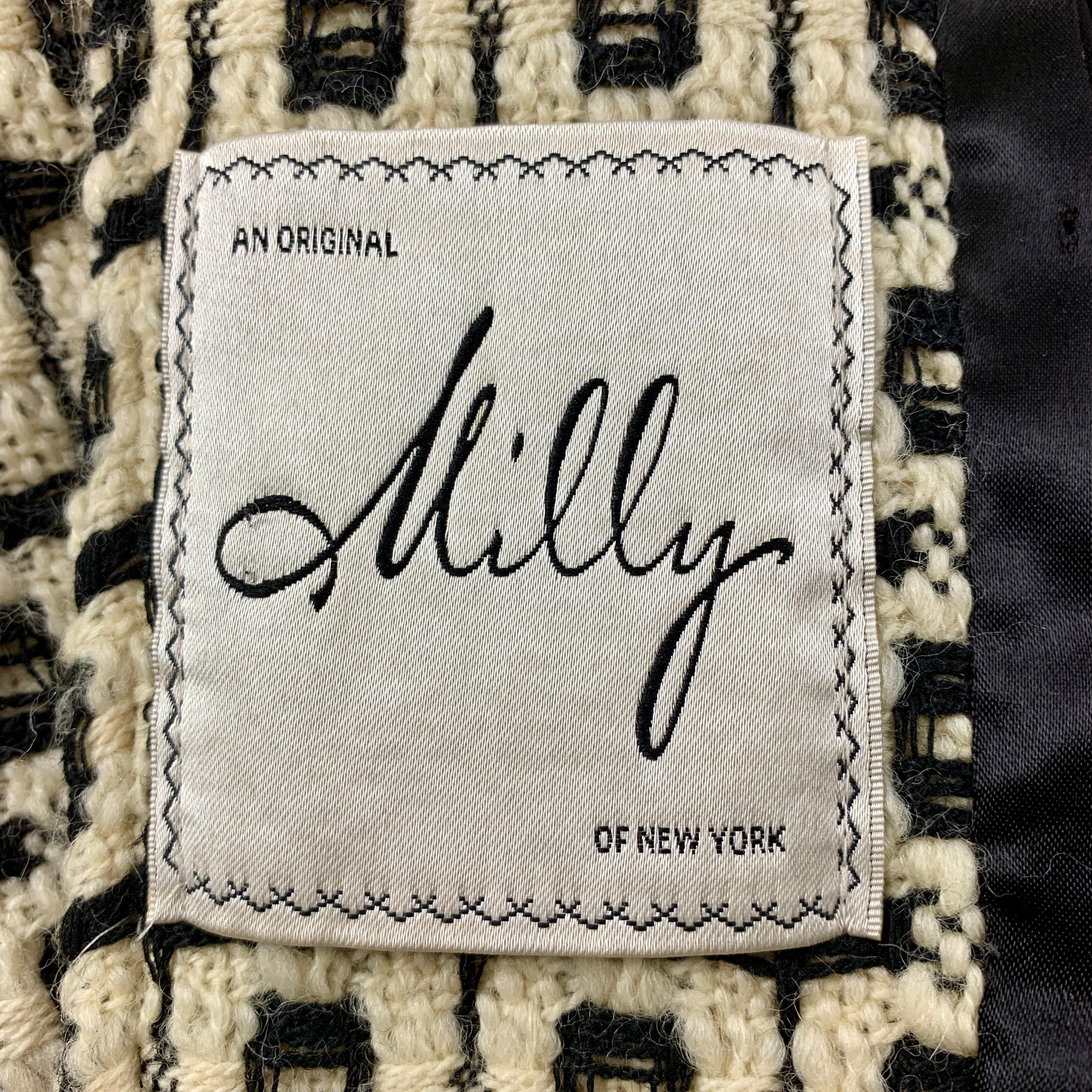 De la collection 2000 de Milly New York, un manteau 100% laine à gros carreaux noirs et blancs. 
Cette pièce montre une belle attention à la ligne et à l'ajustement. Un large col pointu, deux poches avant, et une fermeture avant avec cinq boutons