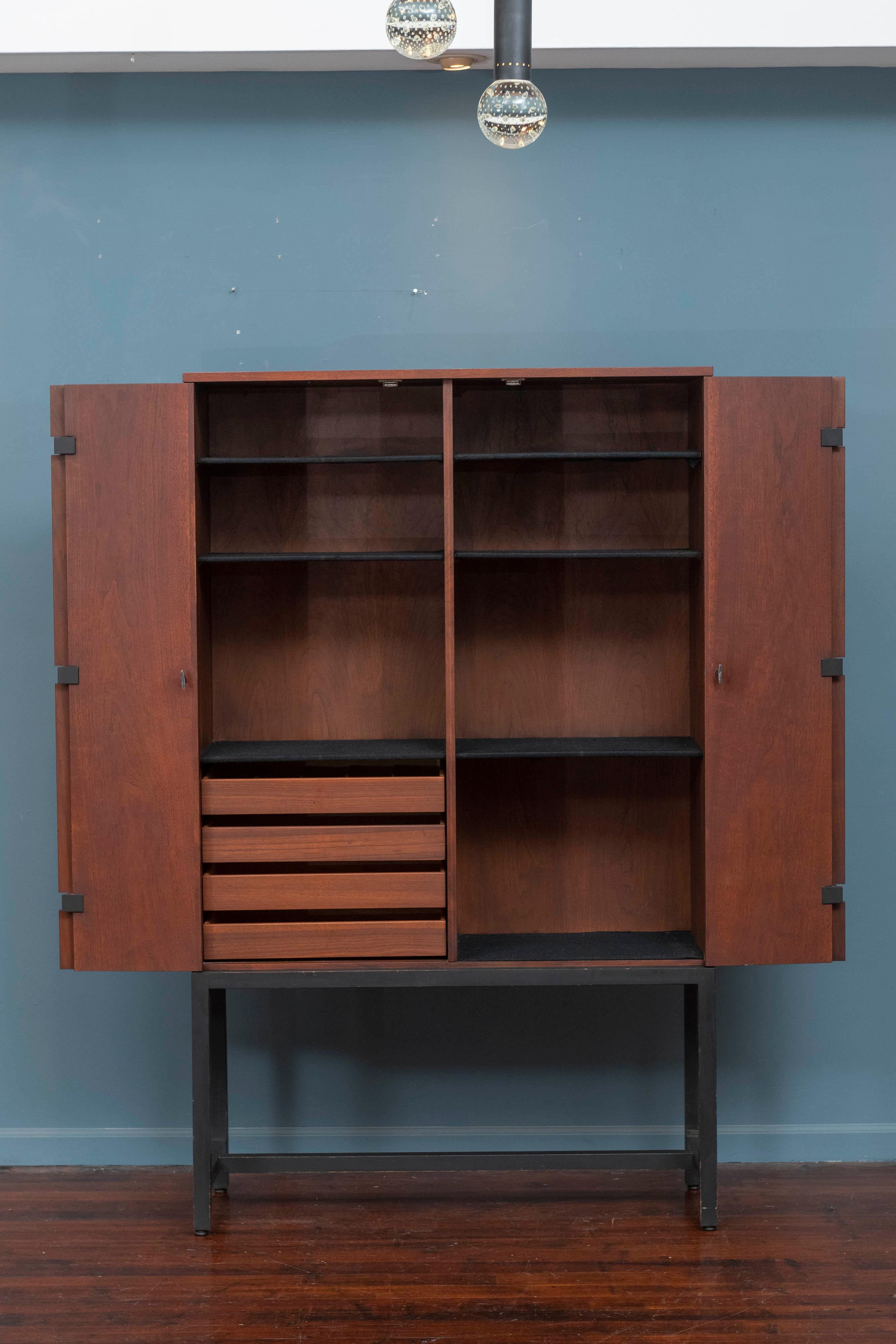 Milo Baughman design bar cabinet for directional furniture. Handsome, refined walnut and black lacquer base bi-fold door bar cabinet with drawers and adjustable shelves.