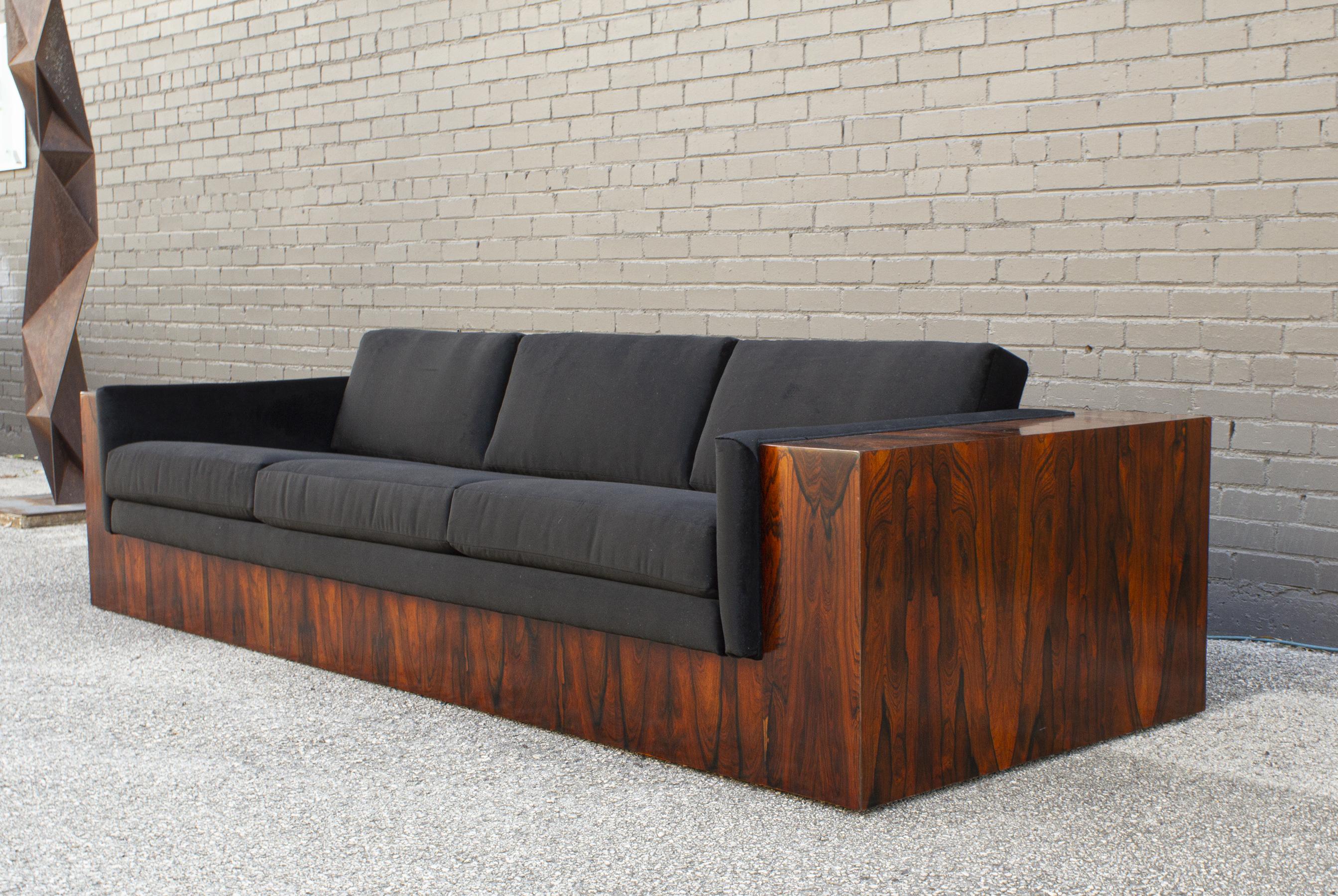 This Milo Baughman-designed case sofa is constructed of highly figured, book-matched Brazilian rosewood and was produced by Thayer Coggin in the early 1970s. The entire case was professionally finished in semi-gloss lacquer that still allows for the